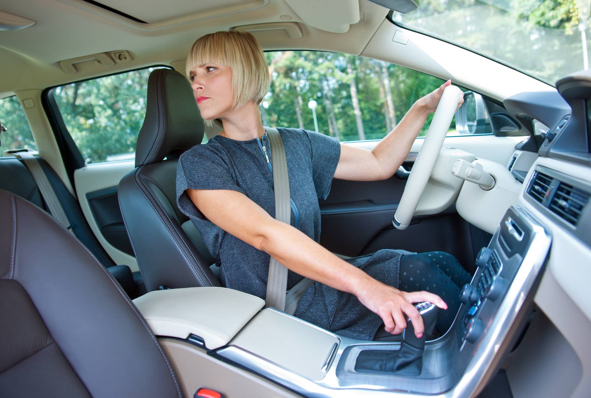 attractive blond woman driver looking back and parking her car