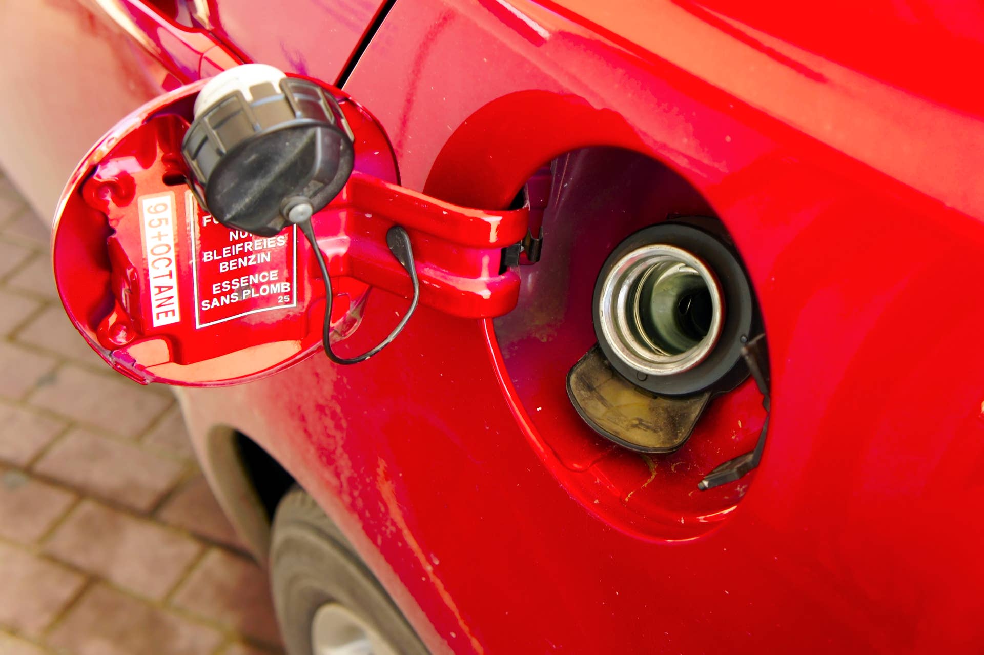 Refuelling fuel tank red car close-up
