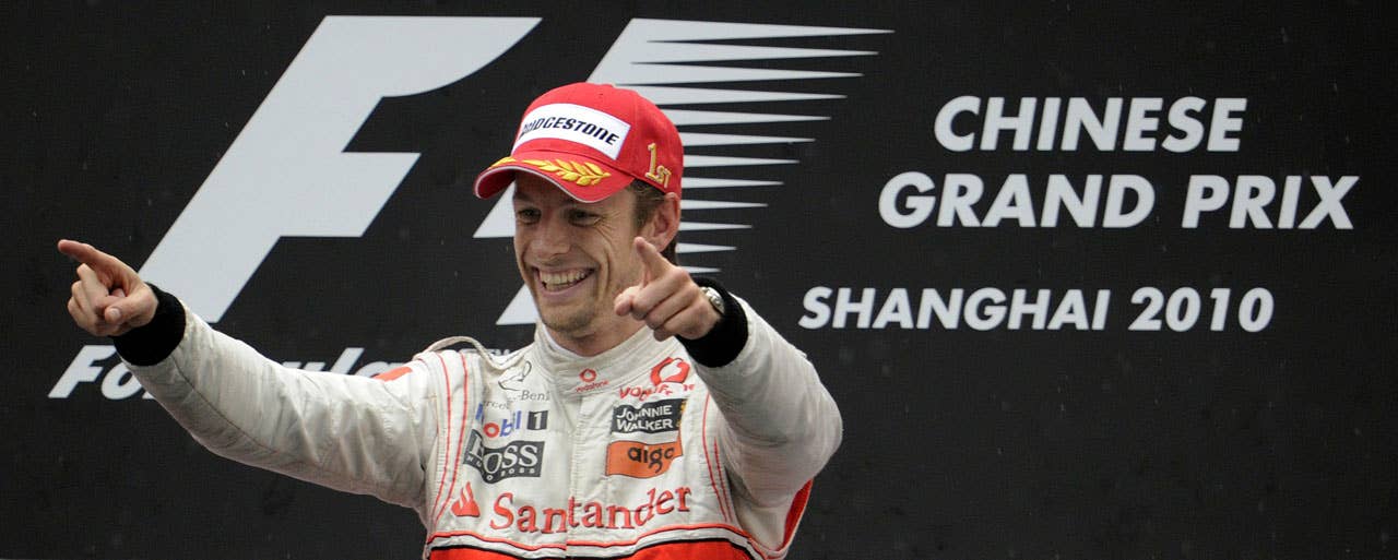 McLaren-Mercedes driver Jenson Button of Britain celebrates on the podium after winning Formula One's Chinese Grand Prix in Shanghai on April 18, 2010. Button won in a time of 1h46:42.163. AFP PHOTO / Peter PARKS (Photo credit should read PETER PARKS/AFP/Getty Images)