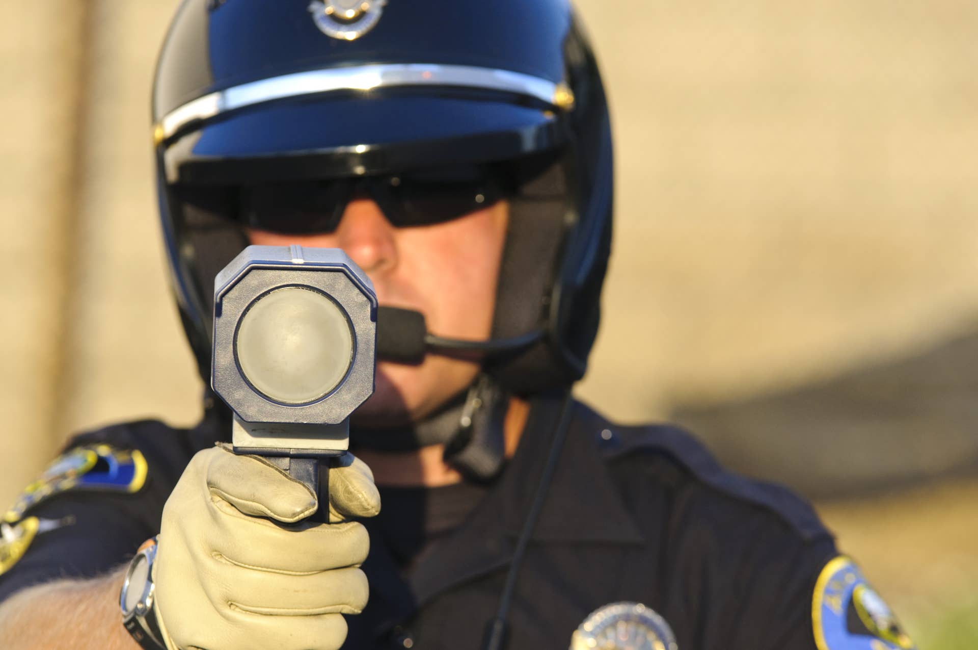 a police officer pointing his radar gun at speeding traffic.