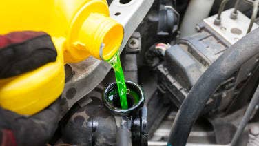 Pouring antifreeze in a car.