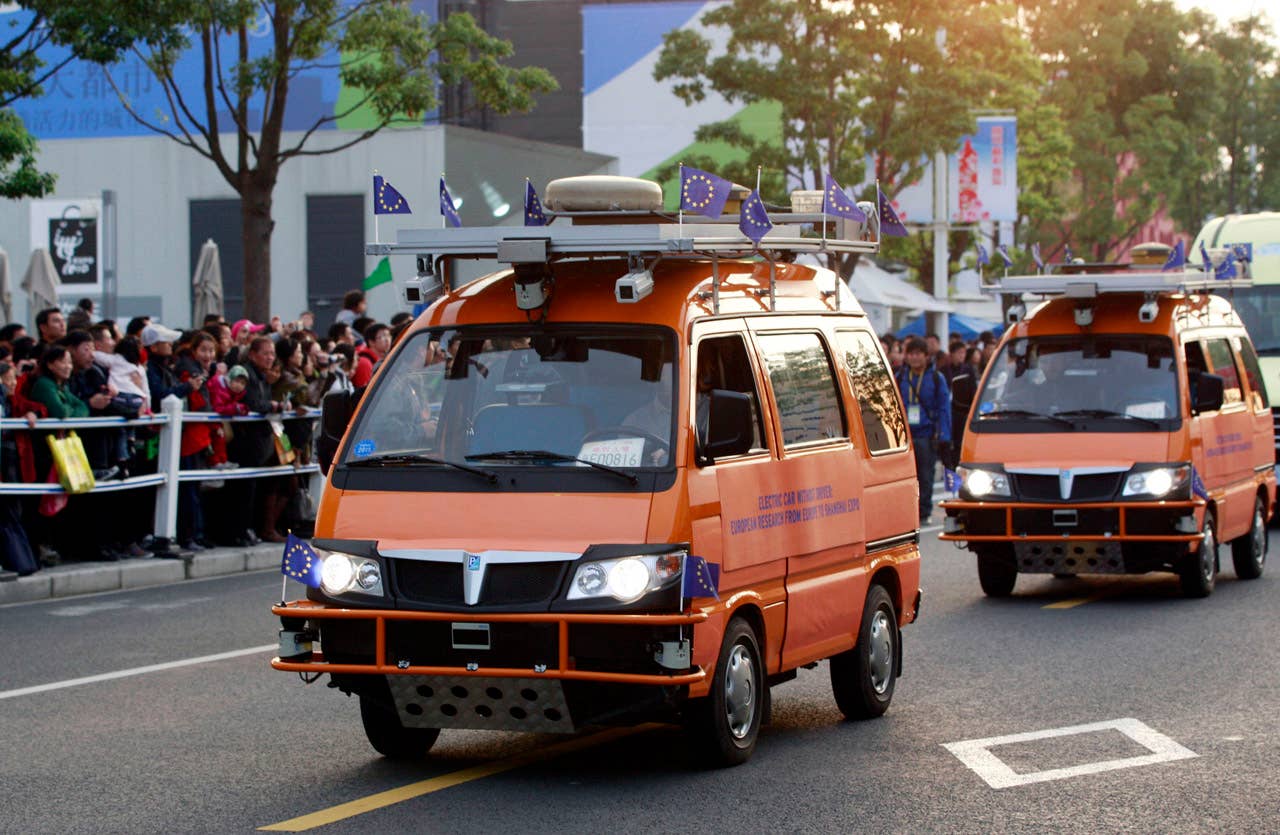 Two driverless vehicles make their way to the World Expo in Shanghai on October 28, 2010. The two bright orange driverless vehicles, equipped with laser scanners and cameras that work in concert to detect and help avoid obstacles, were launched by a team of Italian engineers which is billed as the longest-ever test drive of driverless vehicles - a 13,000-kilometer (8,000-mile), three-month road trip from Italy to China.         CHINA OUT        AFP PHOTO (Photo credit should read STR/AFP/Getty Images)