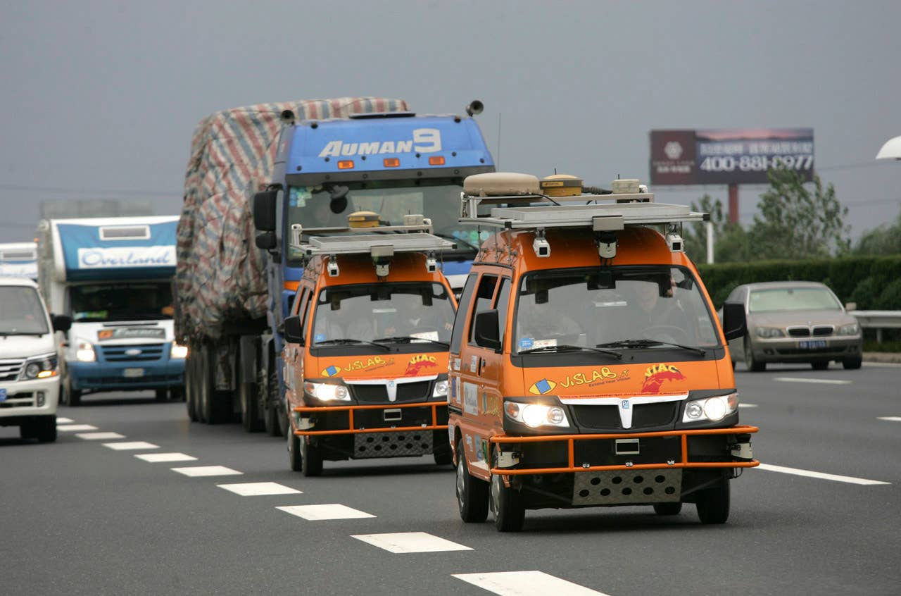 Two bright orange driverless vehicles, equipped with laser scanners and cameras to detect and help avoid obstacles, travel on the highway Tuesday Oct. 26, 2010 in Shanghai, China. A team of Italian engineers launched what has been billed as the longest-ever test drive of driverless vehicles: a 13,000-kilometer (8,000-mile), three-month road trip from Italy to China. (AP Photo)