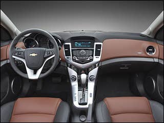 Acres of hard, poorly-fitting plastic used to define economy car interiors. Not so anymore. Looking inside the new Cruze, it's roomy cabin is fully modern. Aluminum finished accents and bold use of color stand grab your attention. The interior's sweeping cockpit design uses high-quality soft-touch plastics and fabrics. Everything fits as it should with clean, even panel gaps. Ten standard airbags provide impressive occupant protection. In addition to ample room up front, those in the rear seats enjoy over 36 inches of legroom and 54 inches of shoulder room. This is 5 inches more than the outgoing Cobalt sedan, and used to be a competitive measurement for a mid-size sedan.Read MoreIn Pictures: 2012 Ford FocusIn Pictures: 2011 Chevy Cruze2010 Detroit Auto Show