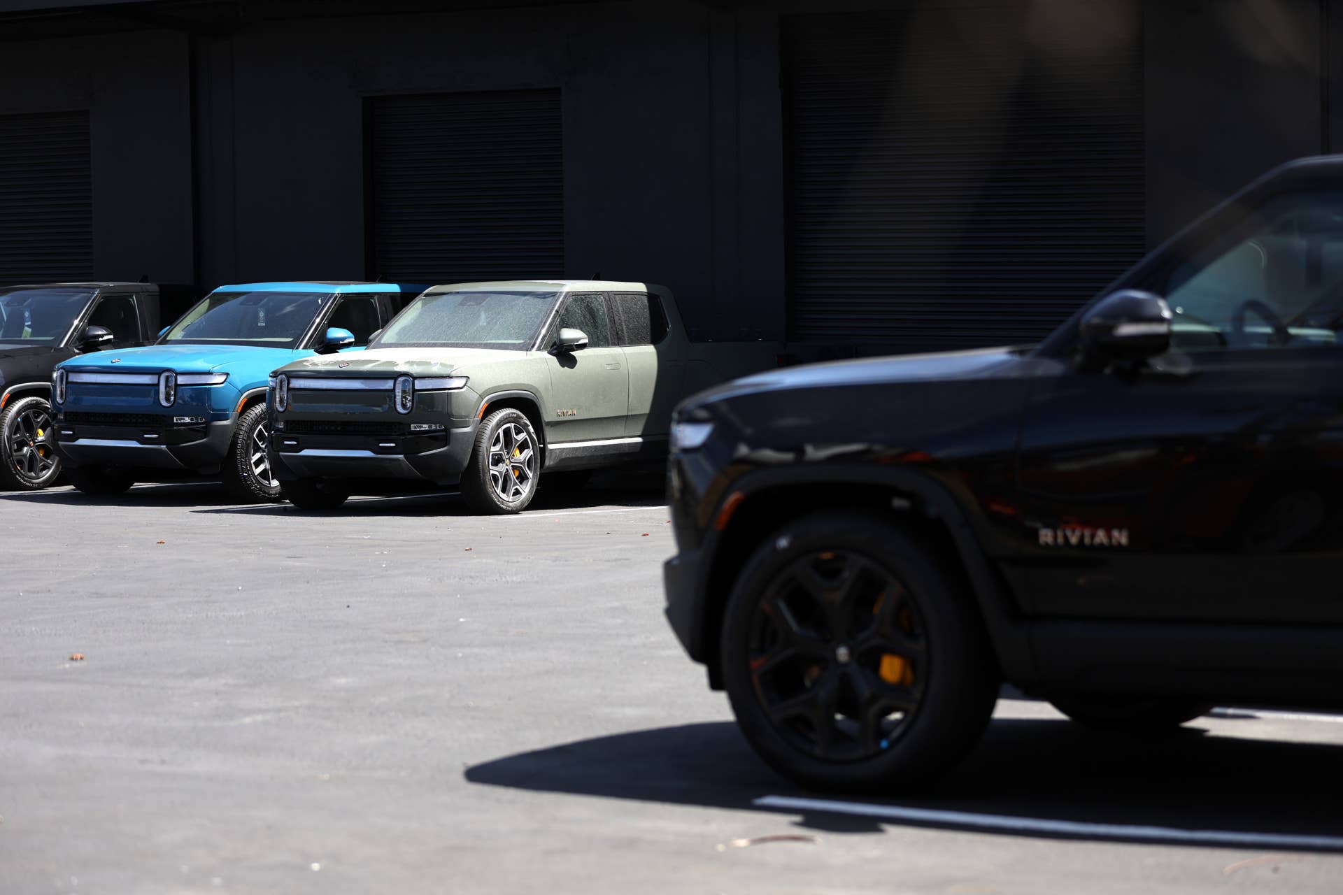 SOUTH SAN FRANCISCO, CALIFORNIA - MAY 09: Rivian electric pickup trucks sit in a parking lot at a Rivian service center on May 09, 2022 in South San Francisco, California. Shares of Rivian stock fell 13 percent after Ford, which currently owns as 11.4 percent stake in the electric car maker, is planning to sell 8 million of its 102 million shares. (Photo by Justin Sullivan/Getty Images)