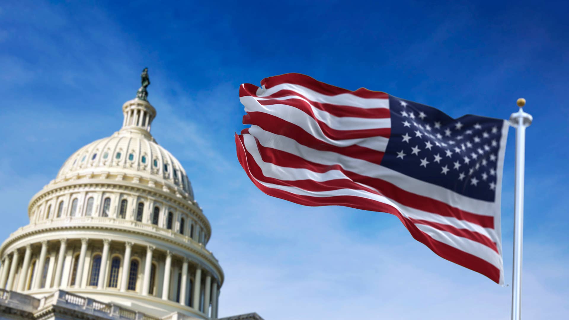 American flag waving with the US Capitol Hill in the background