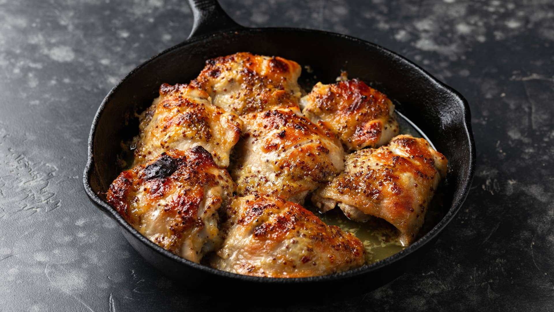 Baked Honey mustard chicken thighs in iron cast pan.