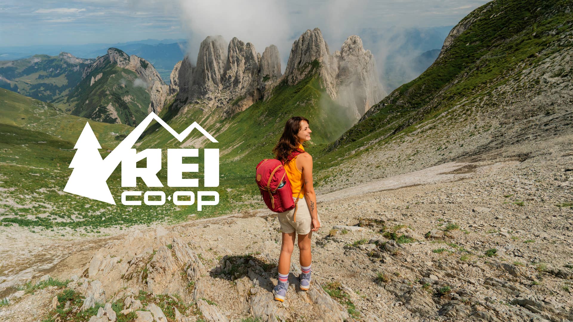 Woman with backpack hiking in Swiss Alps at high altitude near the rescue hut