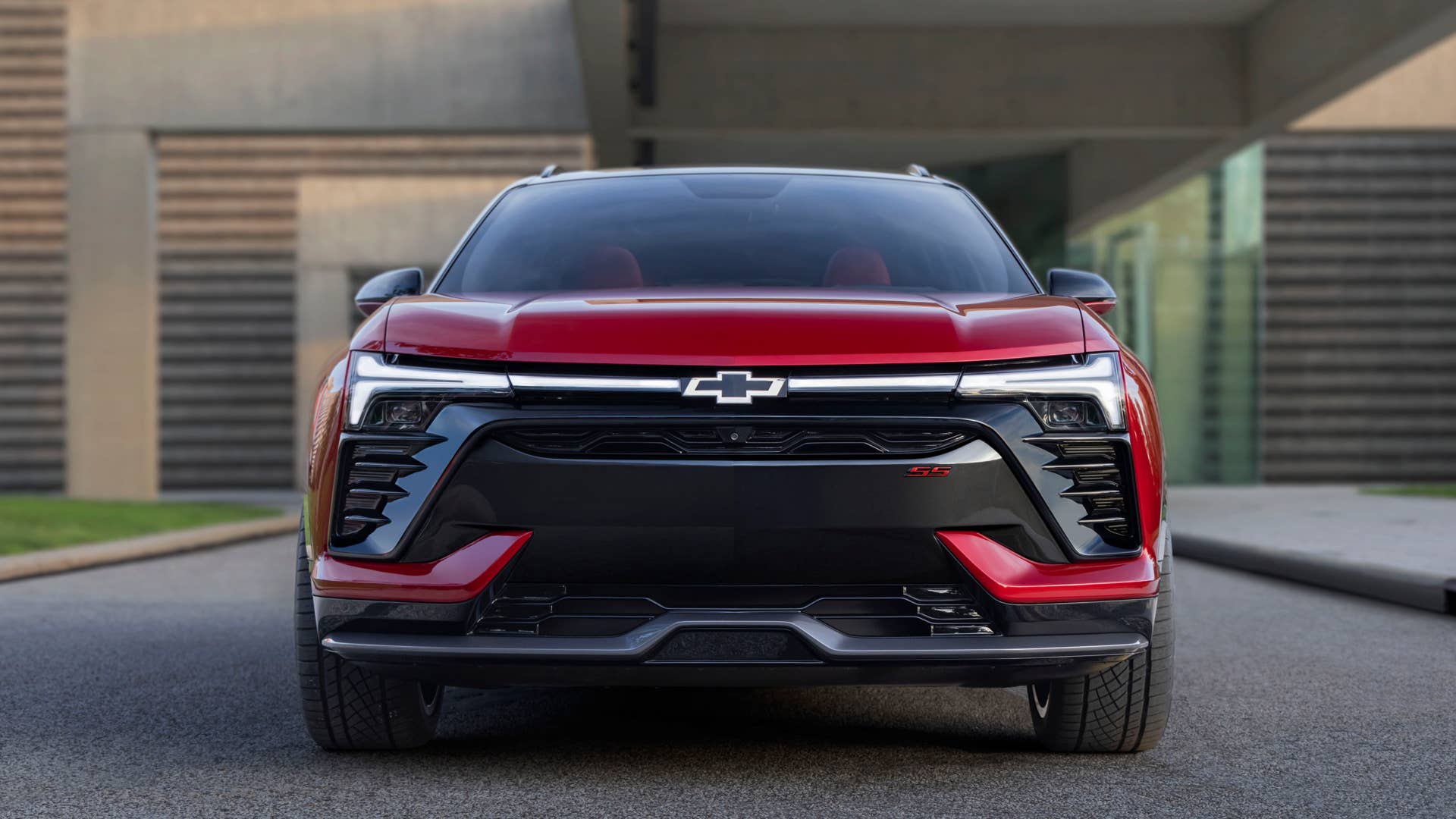 Front view of 2024 Chevrolet Blazer EV SS in Radiant Red Metallic with headlights illuminated. Preproduction model shown. Actual production model may vary. 2024 Chevrolet Blazer EV available Spring 2023.