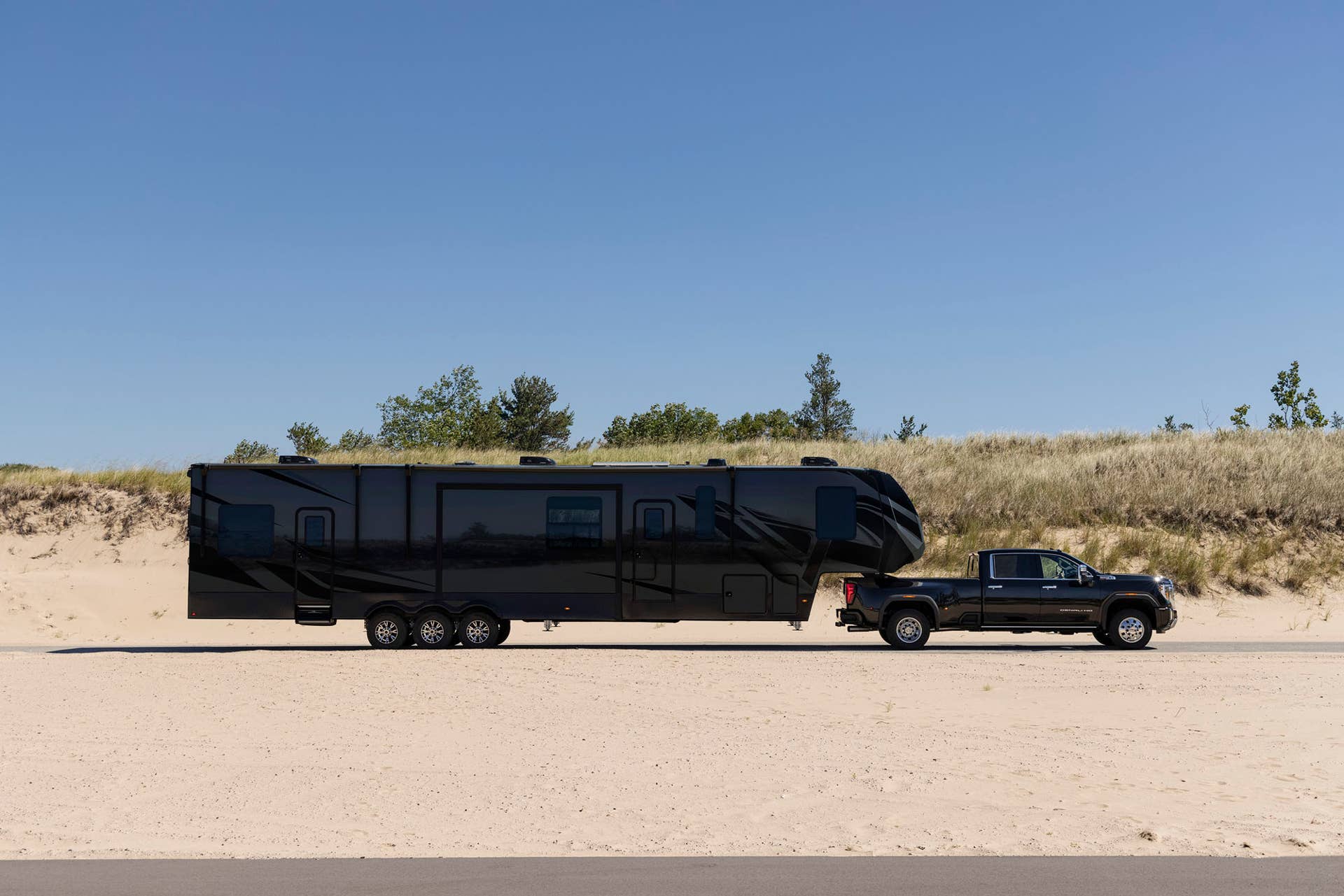 Side view of the GMC Sierra 3500 HD Denali towing a trailer