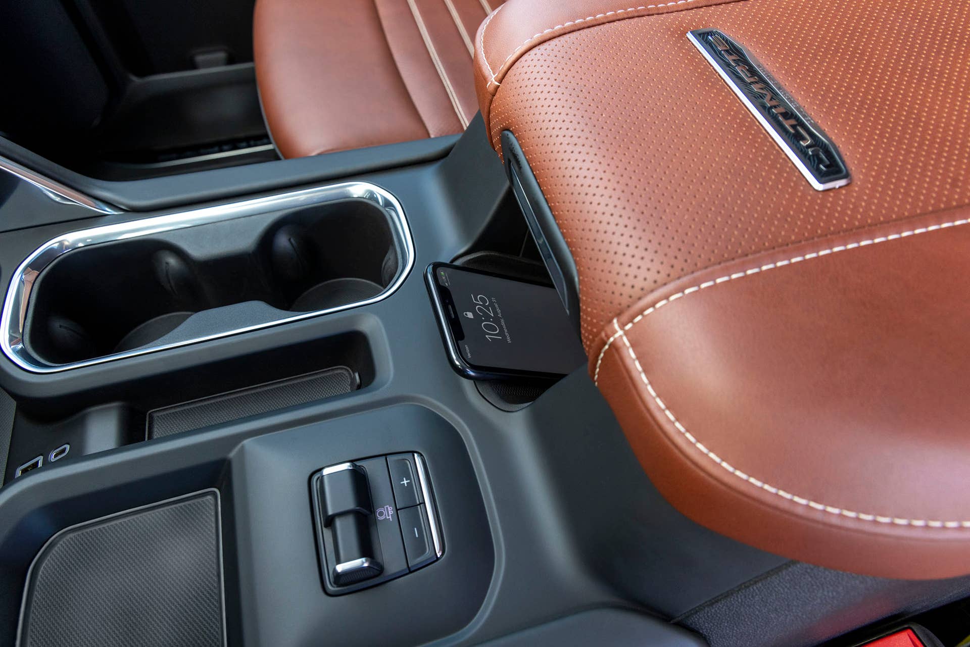 Interior close-up shot of the GMC Sierra 2500 HD Denali Ultimate center console and wireless phone charger