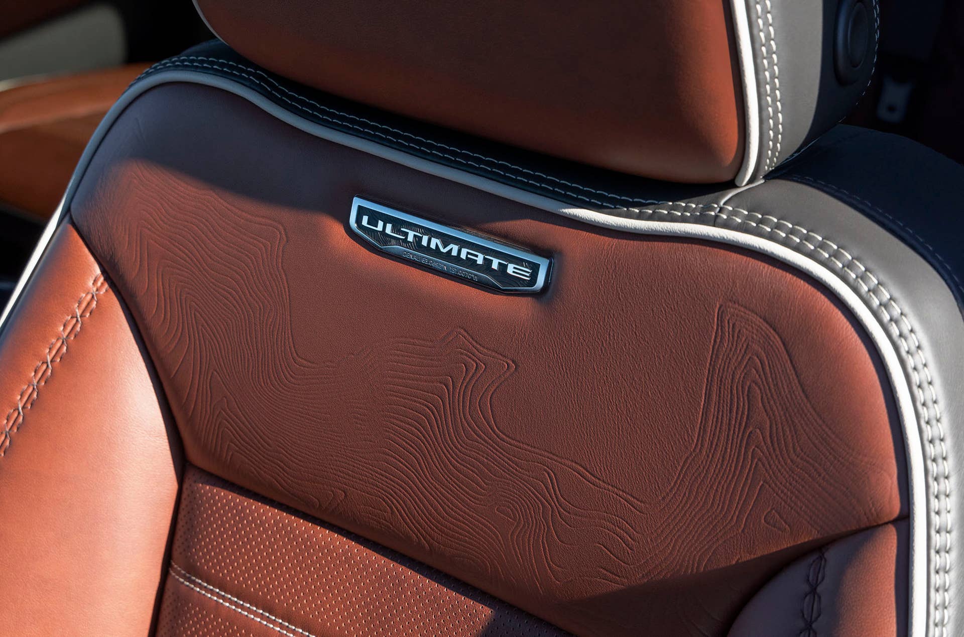 Interior view of GMC Sierra 2500 HD Denali Ultimate full-grain leather front seat with the Denali Ultimate badge