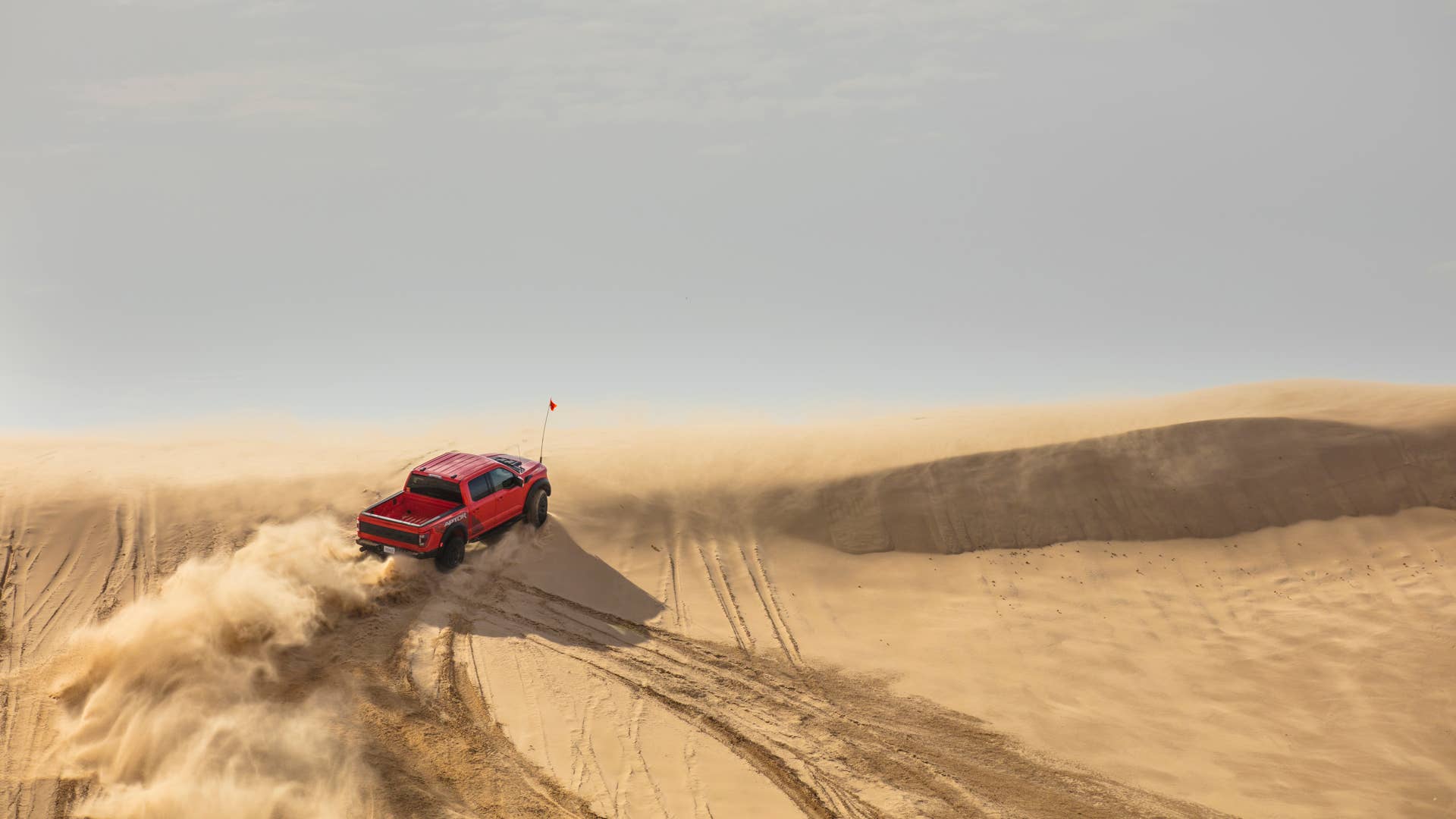 Preproduction 2023 F-150 Raptor R with aftermarket flag and optional equipment. Available late 2022. Professional driver on a closed course. Always consult the Raptor supplement to the Owner’s Manual before off-road driving, know your terrain and trail difficulty, and use appropriate safety gear.