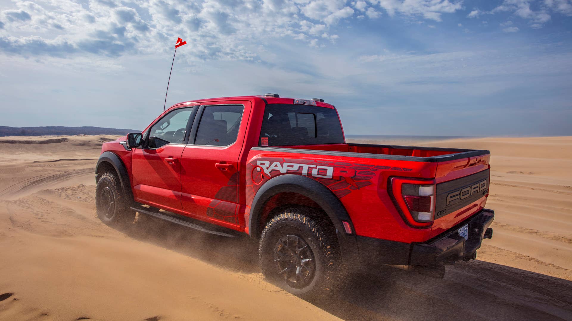 Preproduction 2023 F-150 Raptor R with aftermarket flag and optional equipment. Available late 2022. Professional driver on a closed course. Always consult the Raptor supplement to the Owner’s Manual before off-road driving, know your terrain and trail difficulty, and use appropriate safety gear.