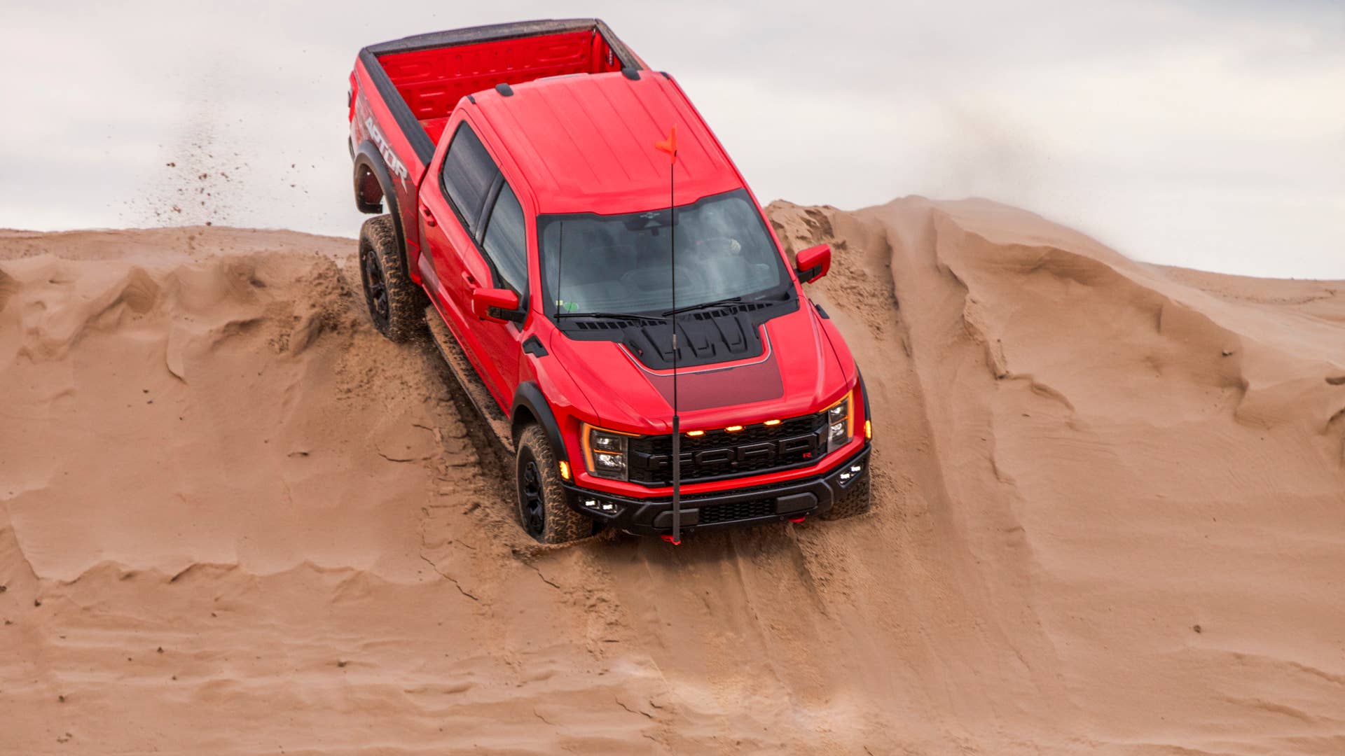 Preproduction 2023 F-150 Raptor R with aftermarket flag and optional equipment. Available late 2022. Professional driver on a closed course. Always consult the Raptor supplement to the Owner’s Manual before off-road driving, know your terrain and trail difficulty, and use appropriate safety gear.