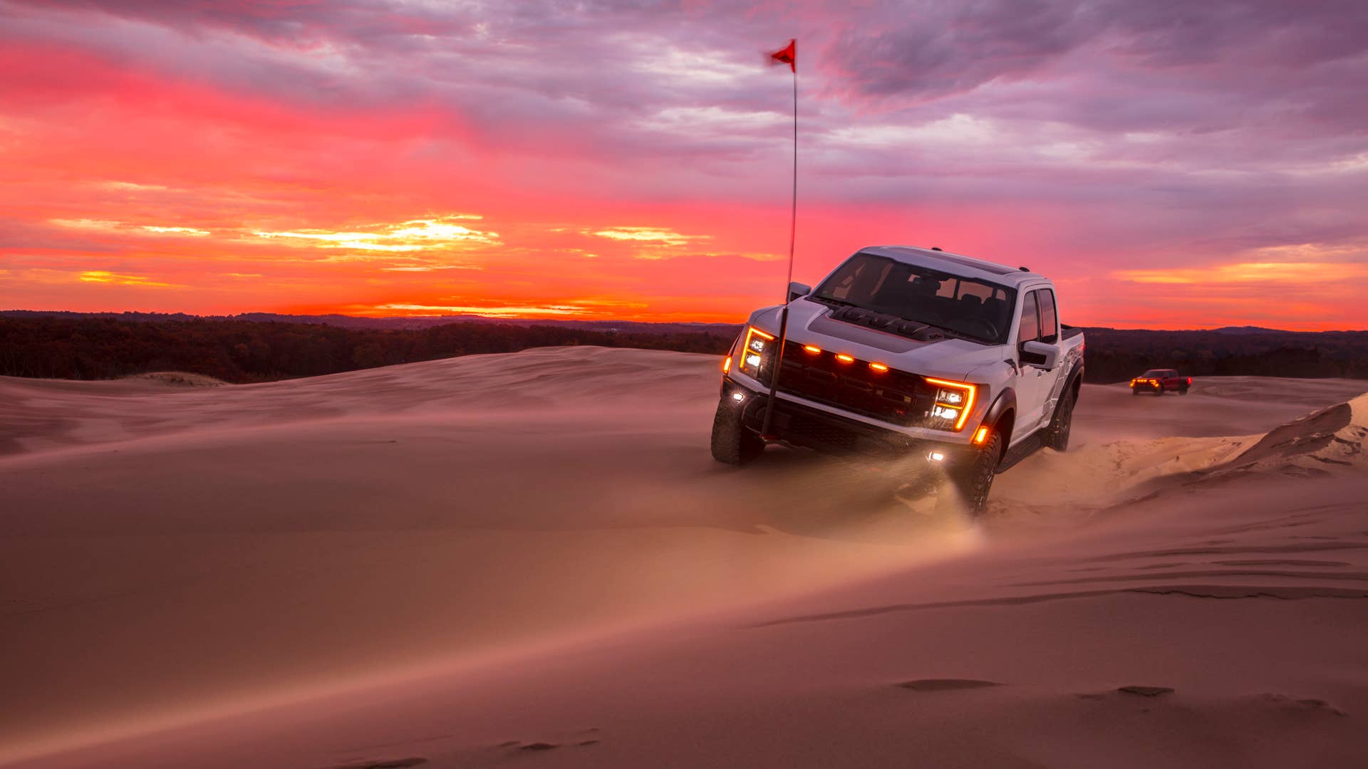 Preproduction 2023 F-150 Raptor R with aftermarket flag and optional equipment. Available late 2022. Professional driver on a closed course. Always consult the Raptor supplement to the Owner’s Manual before off-road driving, know your terrain and trail difficulty, and use appropriate safety gear.