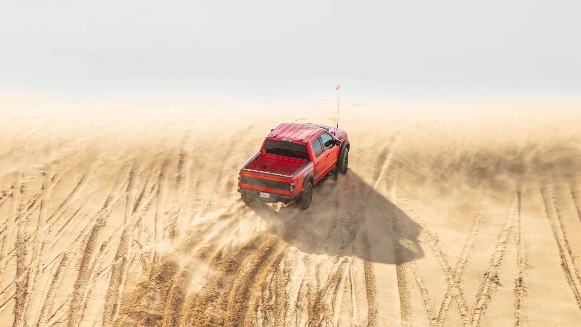 Preproduction 2023 F-150 Raptor R with aftermarket flag and optional equipment. Available late 2022. Professional driver on a closed course. Always consult the Raptor supplement to the Owner’s Manual before off-road driving, know your terrain and trail difficulty, and use appropriate safety gear.