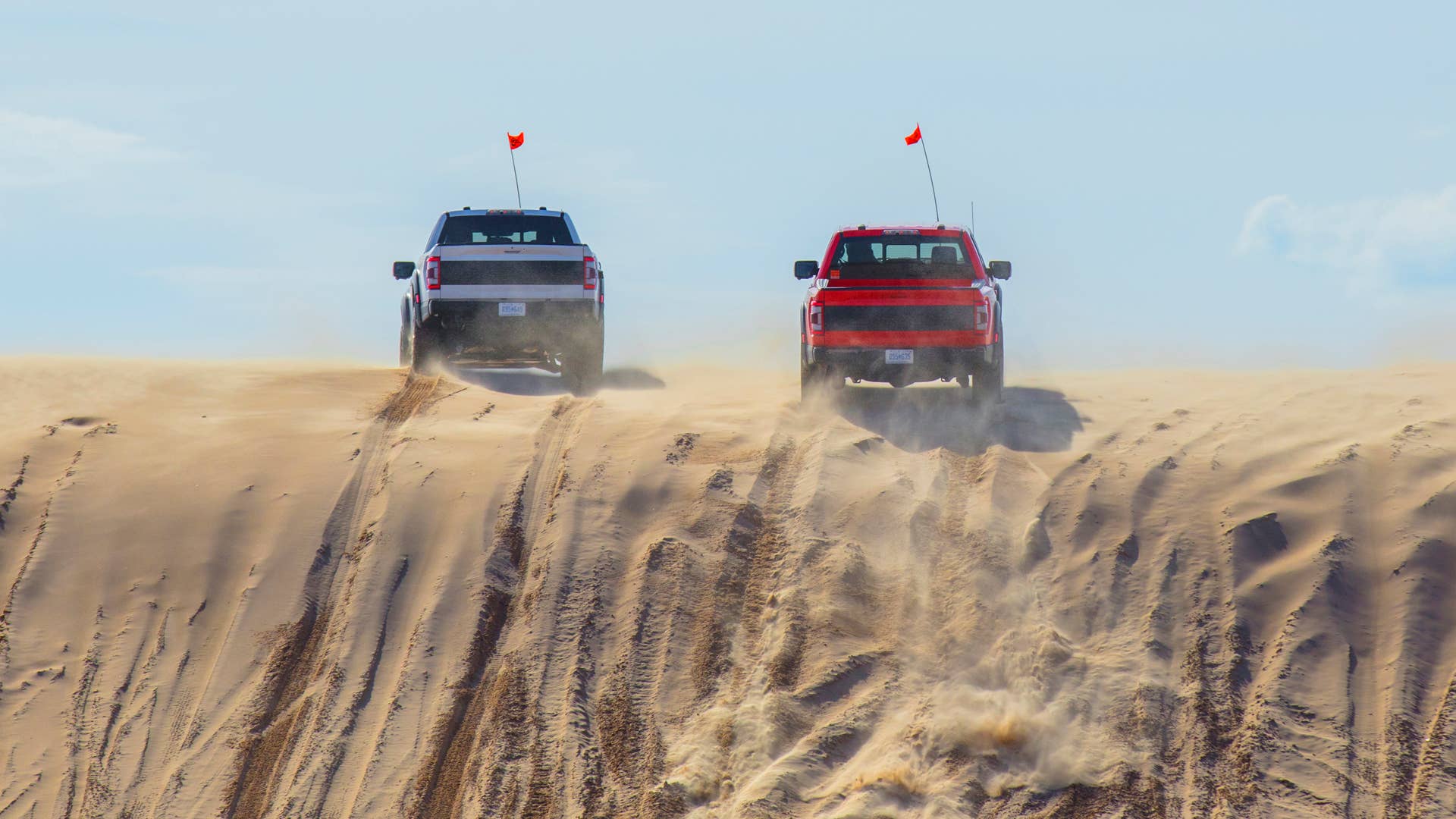 Preproduction 2023 F-150 Raptor R with aftermarket flag and optional equipment. Available late 2022. Professional driver on a closed course. Always consult the Raptor supplement to the Owner’s Manual before off-road driving, know your terrain and trail difficulty, and use appropriate safety gear.