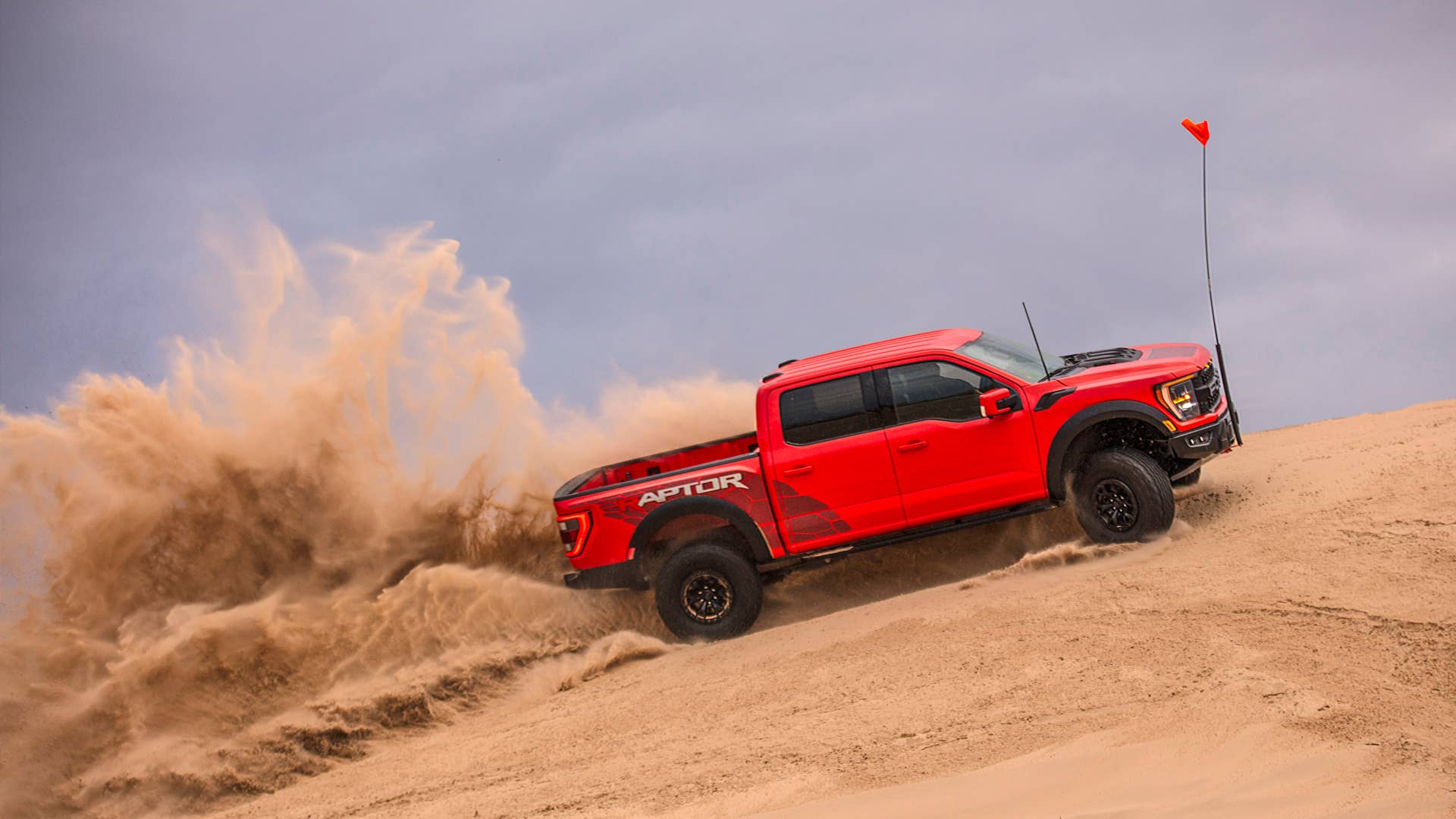 Preproduction 2023 F-150 Raptor R with aftermarket flag and optional equipment. Available late 2022. Professional driver on a closed course. Always consult the Raptor supplement to the Owner’s Manual before off-road driving, know your terrain and trail difficulty, and use appropriate safety gear.