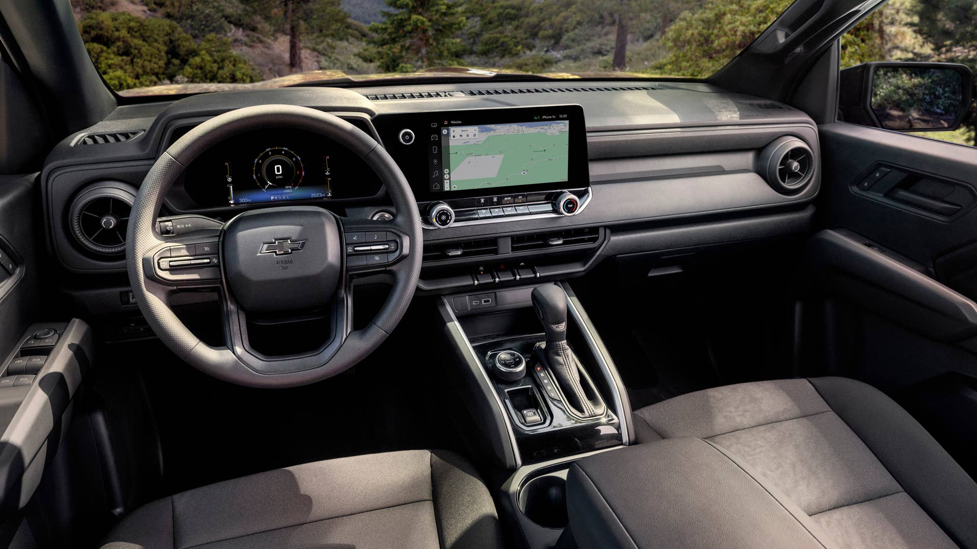 View of Colorado Trail Boss interior from driver's perspective with forrest view through front windshield.