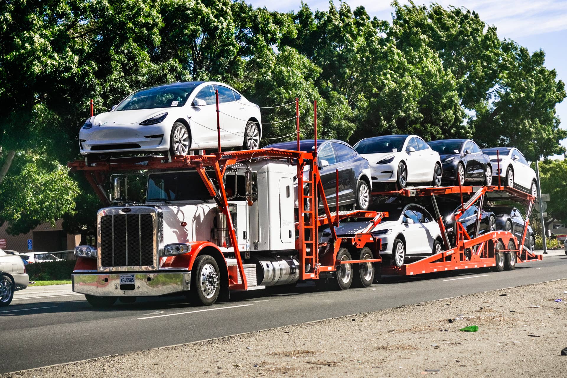 June 28, 2019 Fremont / CA / USA - Car transporter carries Tesla Model 3 new vehicles from the nearby company factory, East San Francisco bay area, front view of the trailer;