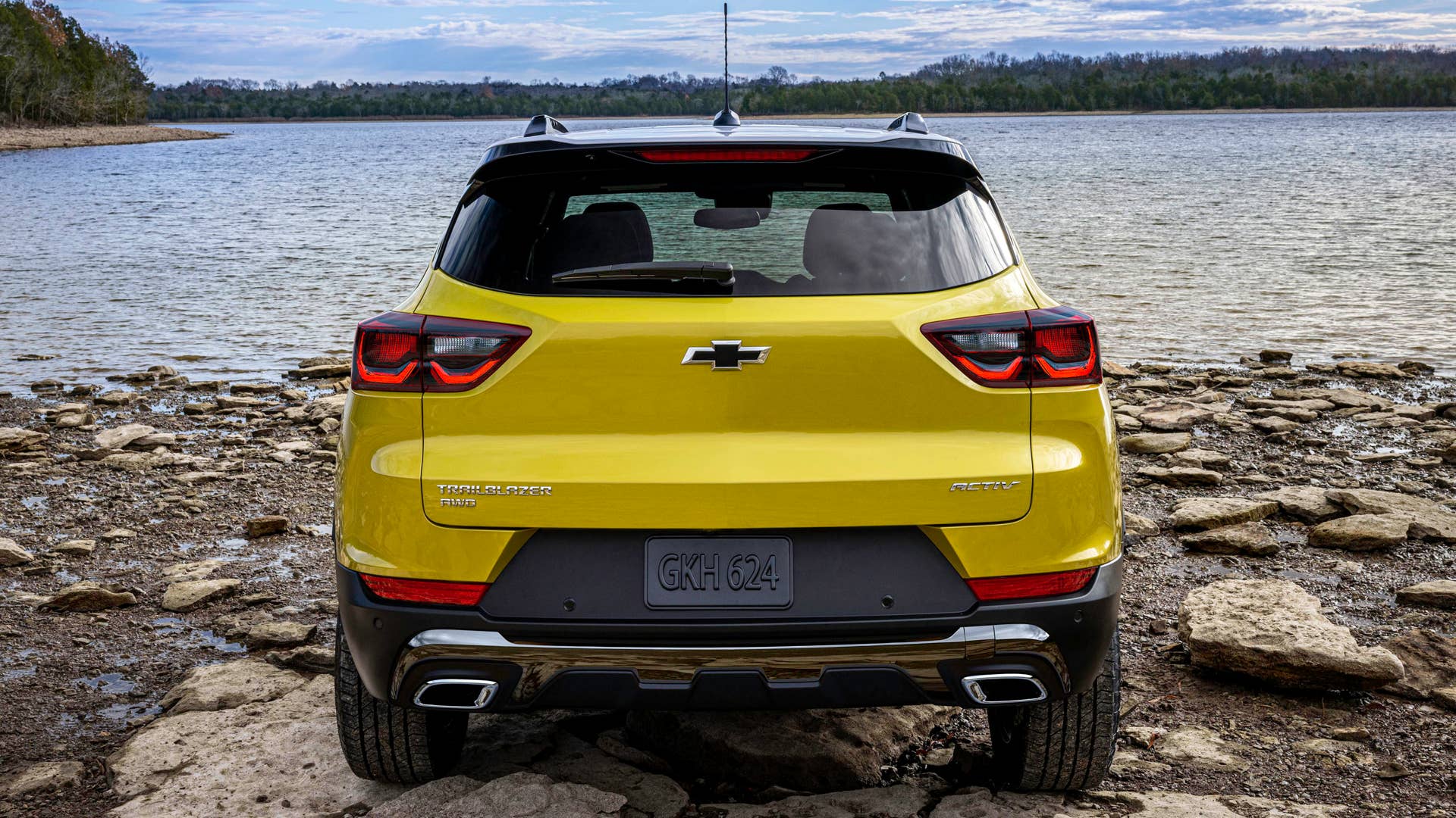 Rear view of 2024 Chevrolet Trailblazer ACTIV parked on rocks in front of a lake. Preproduction model shown. Actual production model may vary. Available in fall 2023.