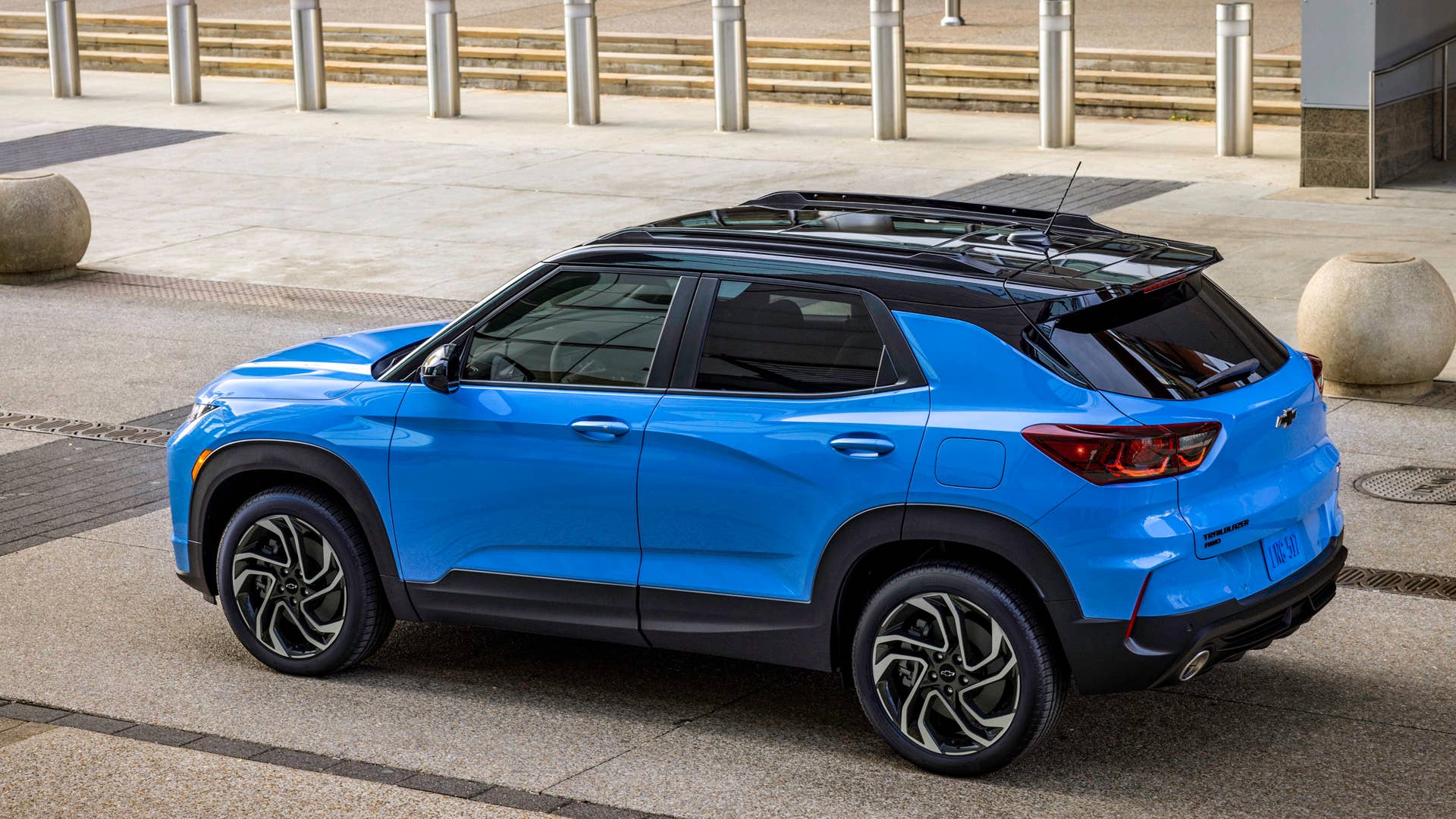 Rear 7/8 view of 2024 Chevrolet Trailblazer RS in Fountain Blue parked in front of a building. Preproduction model shown. Actual production model may vary. Available in fall 2023.