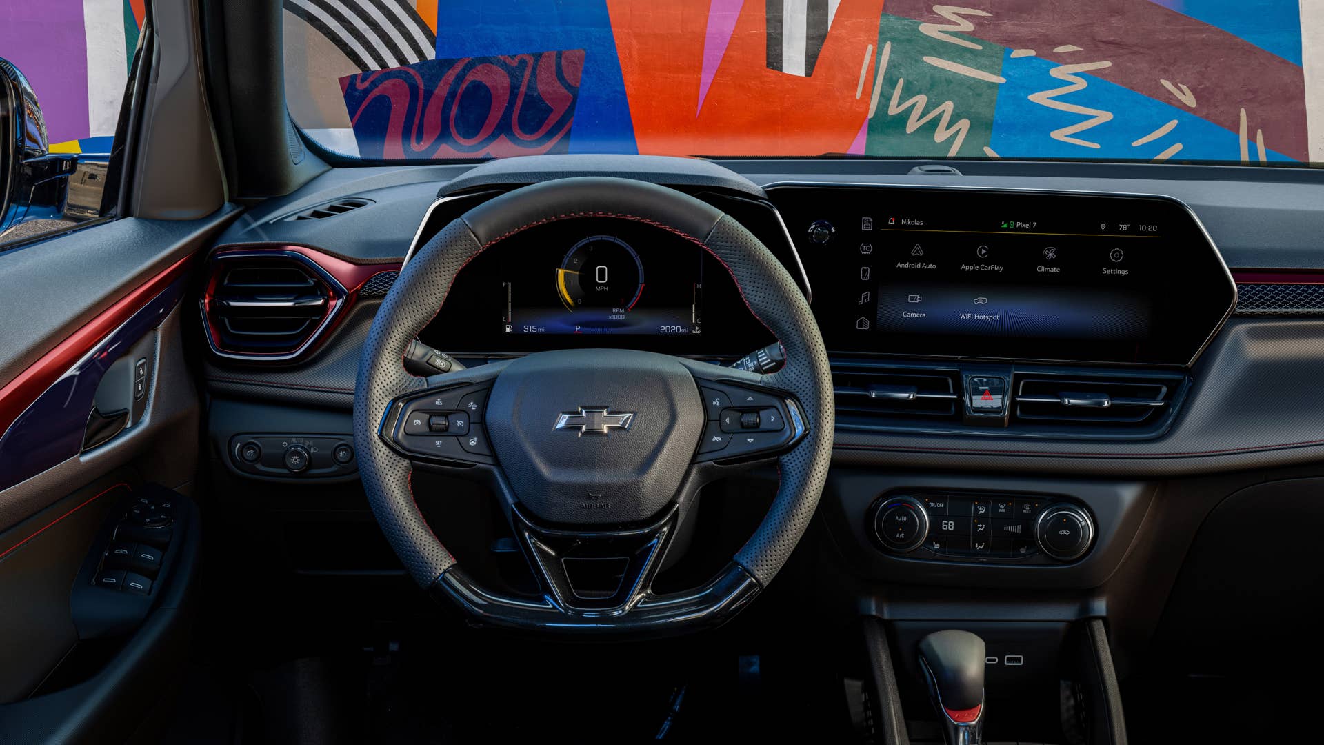 View of steering wheel and infotainment screen in front cabin of 2024 Chevrolet Trailblazer RS with Jet Black with Red Accents interior. Preproduction model shown. Actual production model may vary. Available in fall 2023.