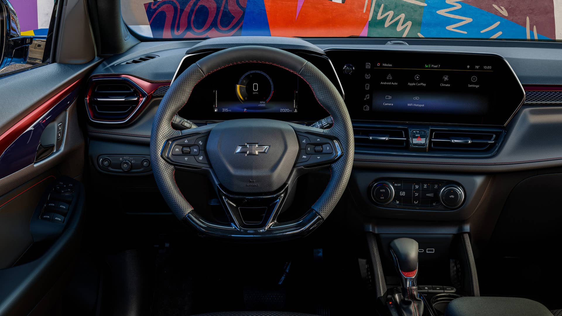 View of steering wheel and infotainment screen in front cabin of 2024 Chevrolet Trailblazer RS with Jet Black with Red Accents interior. Preproduction model shown. Actual production model may vary. Available in fall 2023.