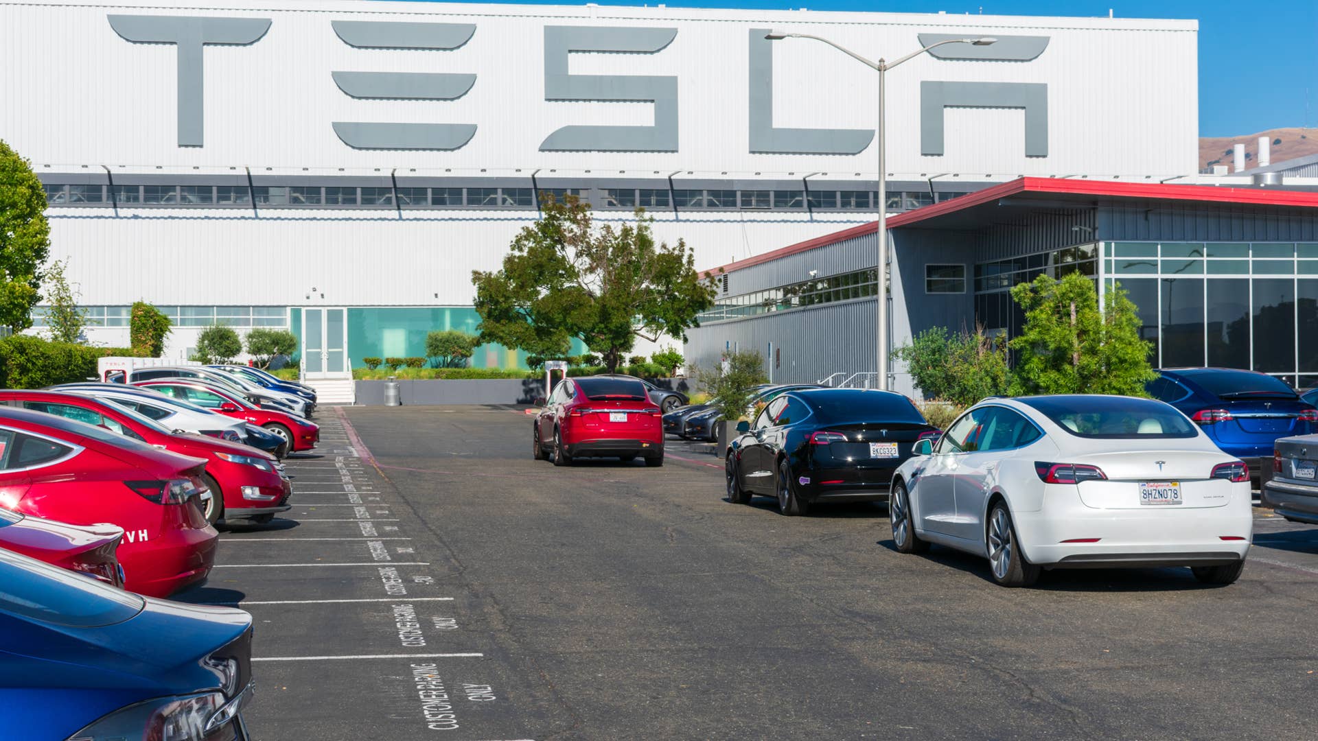 Tesla logo displayed on the exterior wall of Tesla Factory, automobile manufacturing plant in Silicon Valley - Fremont, CA, USA - Circa, 2019