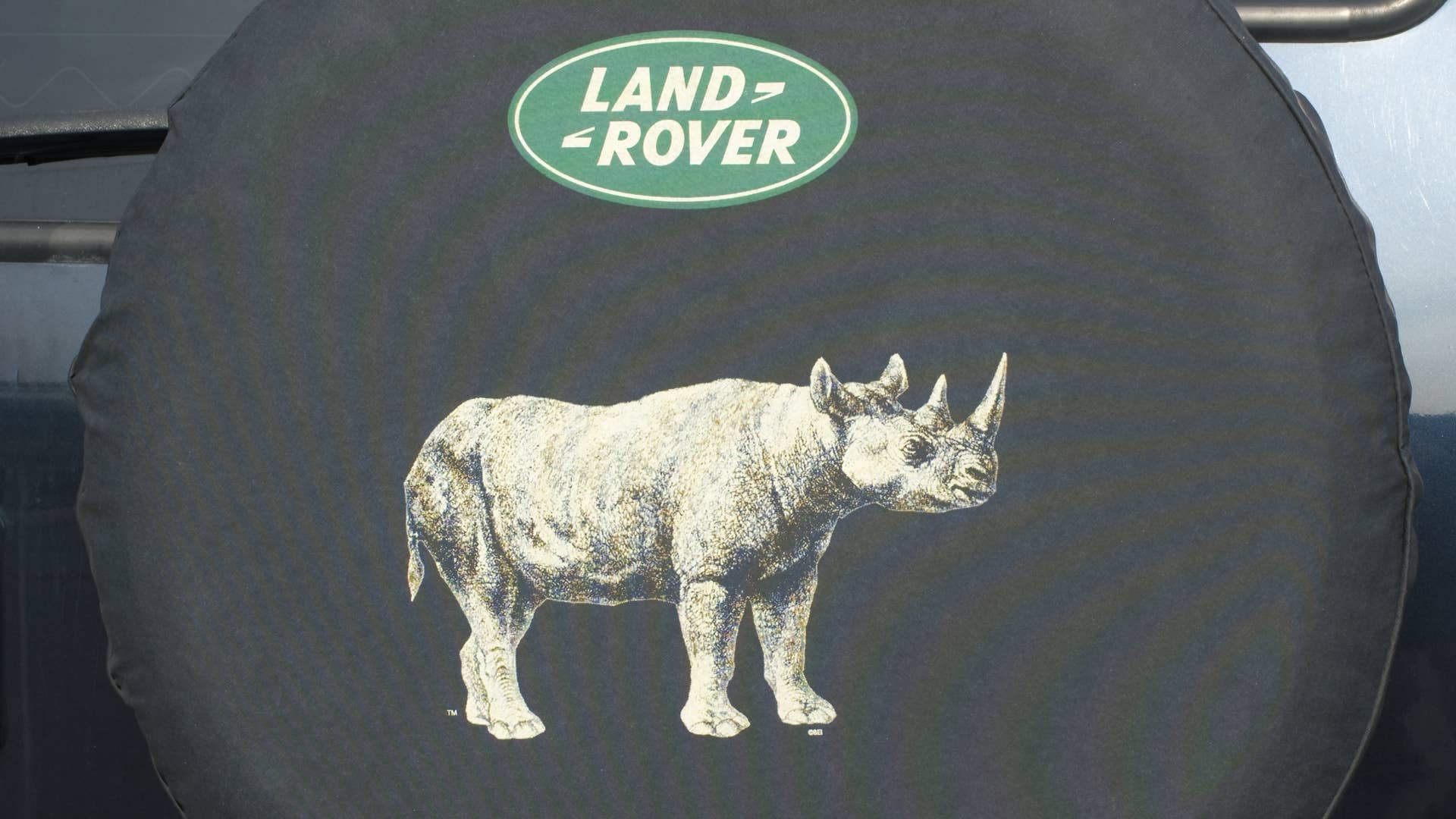 OCALA, FLORIDA USA - OCTOBER 22, 2023 Land Rover rhino tire cover with green oval logo on back of dirty off road 4x4 vehicle. Jaguar Land Rover Limited is a British multinational automotive company.