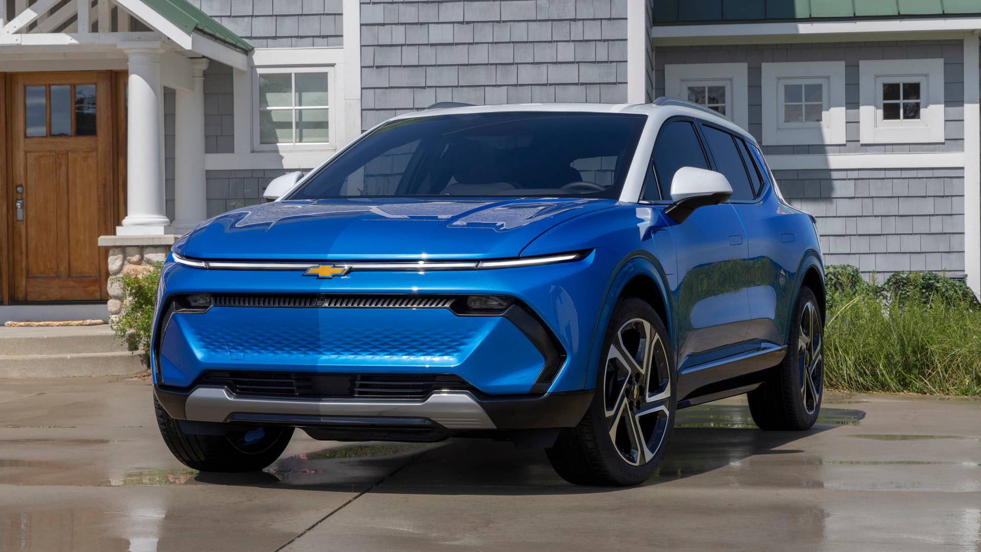 Seven-eighths view of 2024 Chevrolet Equinox EV 3LT in Riptide Blue parked in front of a home. Preproduction model shown. Actual production model may vary. 2024 Chevrolet Equinox EV available Fall 2023.