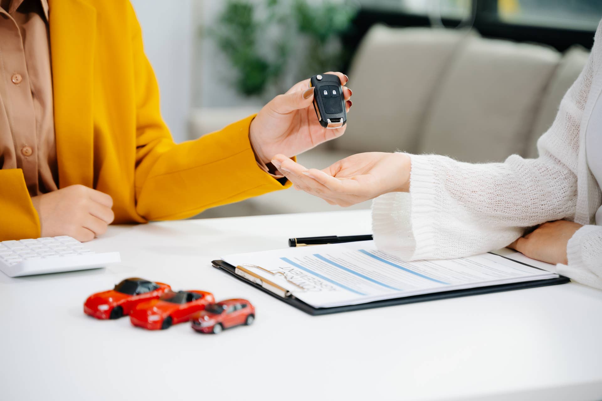 Asian people car salesman or sales manager offers to sell a car and explains of signing a car contract and signing car insurance document or lease paper.