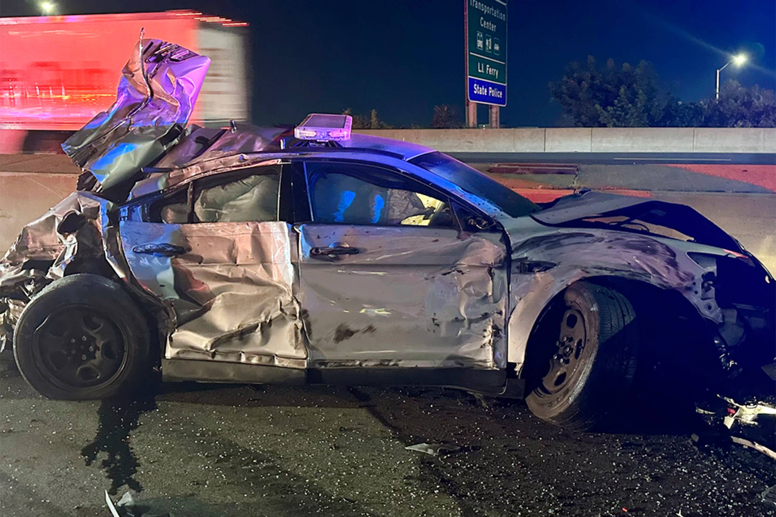 This image released by the Connecticut State Police, Tuesday, July 18, 2023, shows one of of two state police cruisers damaged when human waste, leaking from a tractor trailer, turned Interstate 95 in Bridgeport, Conn., into a virtual skating rink, causing multiple crashes, Monday night, July 17, 2023. State police charged the driver with reckless driving, reckless endangerment and failing to secure a load. (Connecticut State Police via AP)