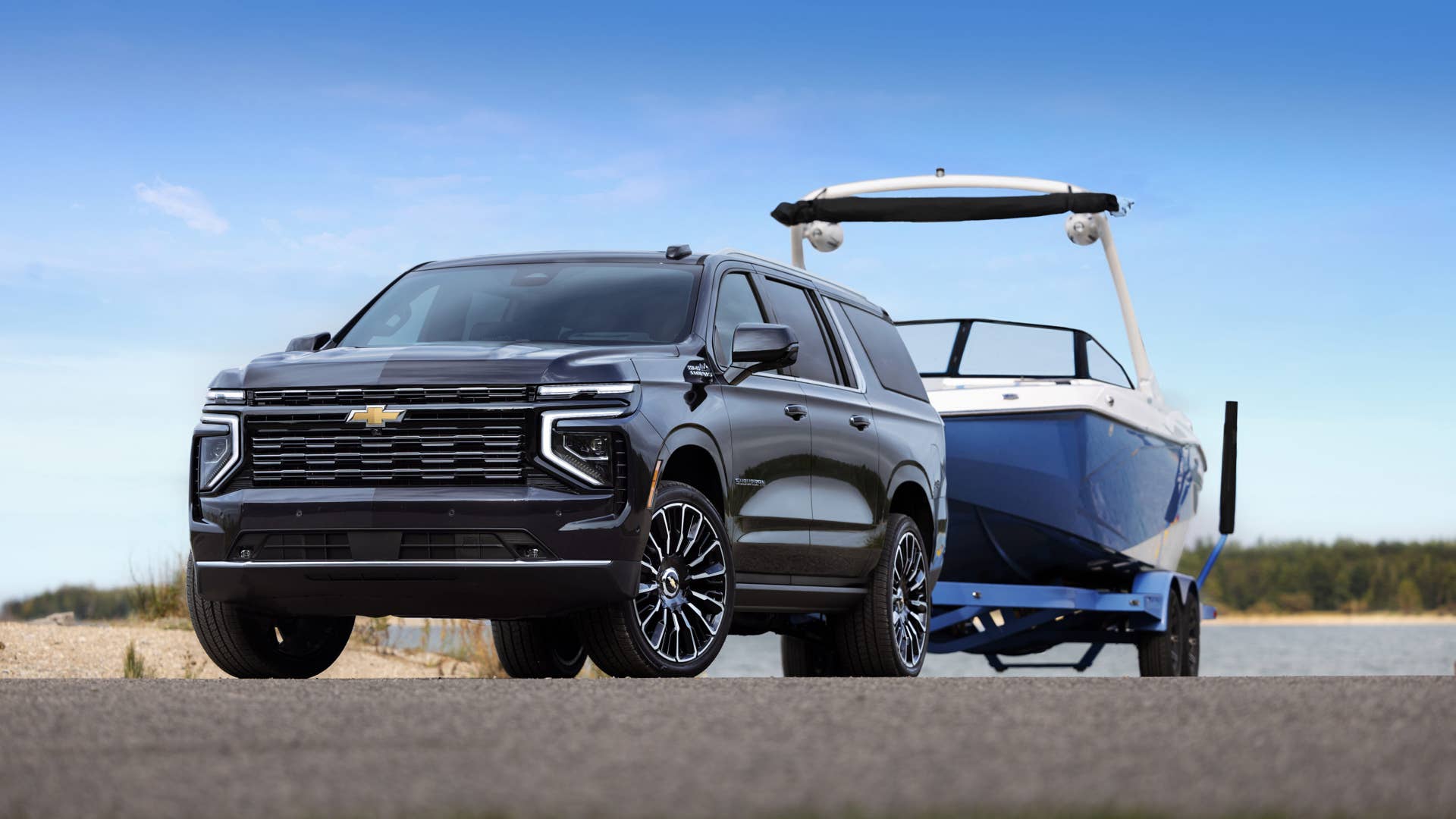 Front 3/4 shot of the 2025 Suburban High Country towing a boat