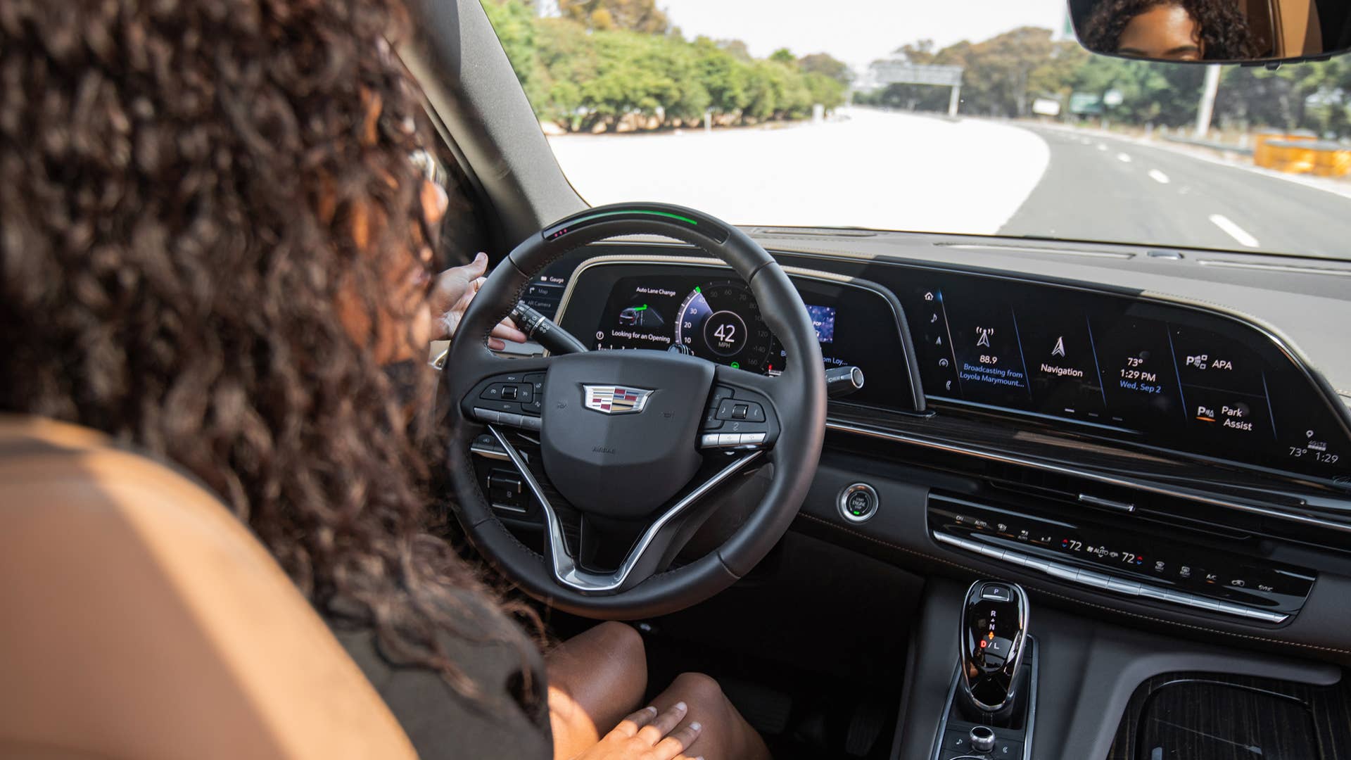 Over the shoulder shot of a woman using Super Cruise, the industry’s first true hands-free driver assistance technology, in a Cadillac Escalade