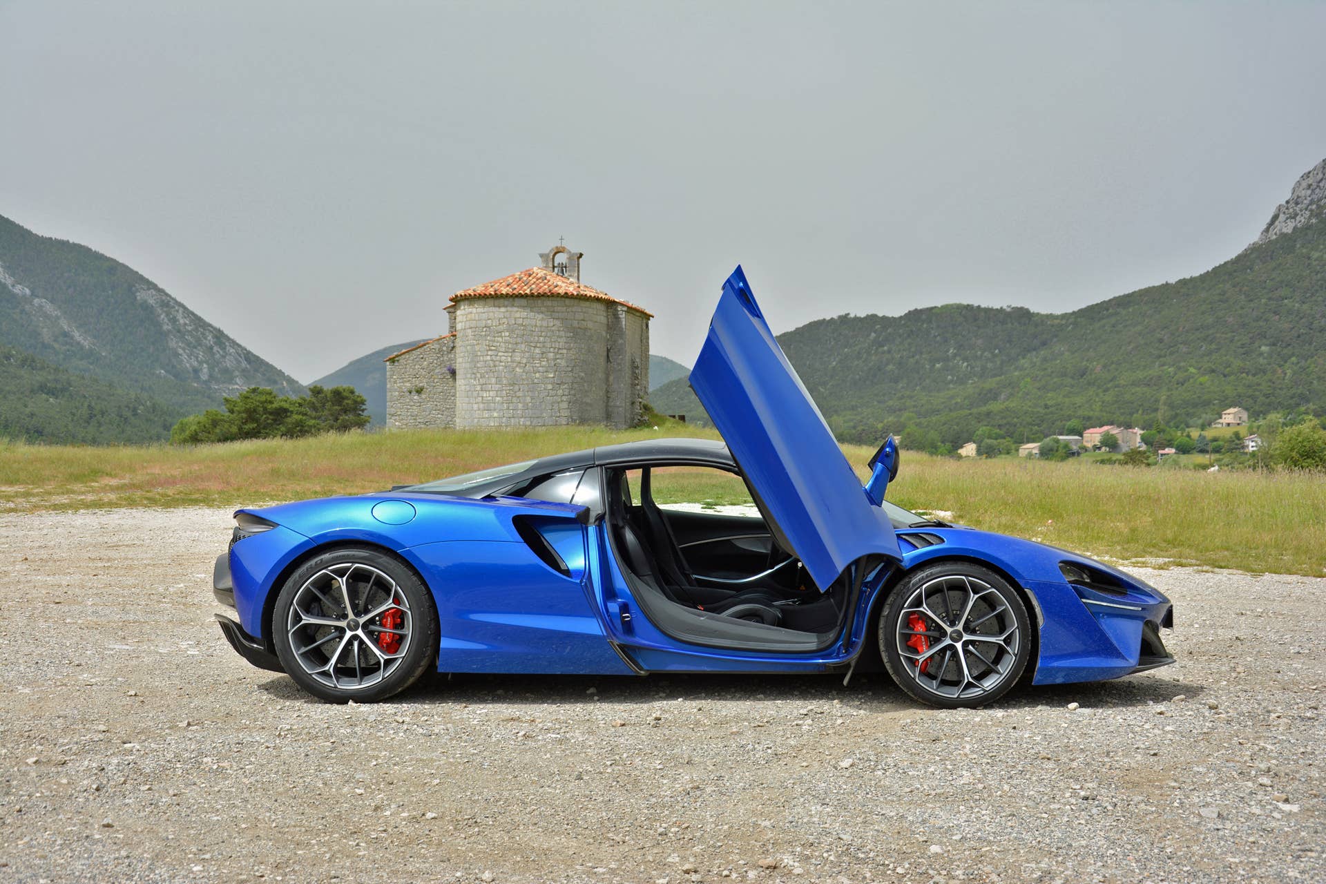 2025 McLaren Artura Spider in blue side view roof up and door open