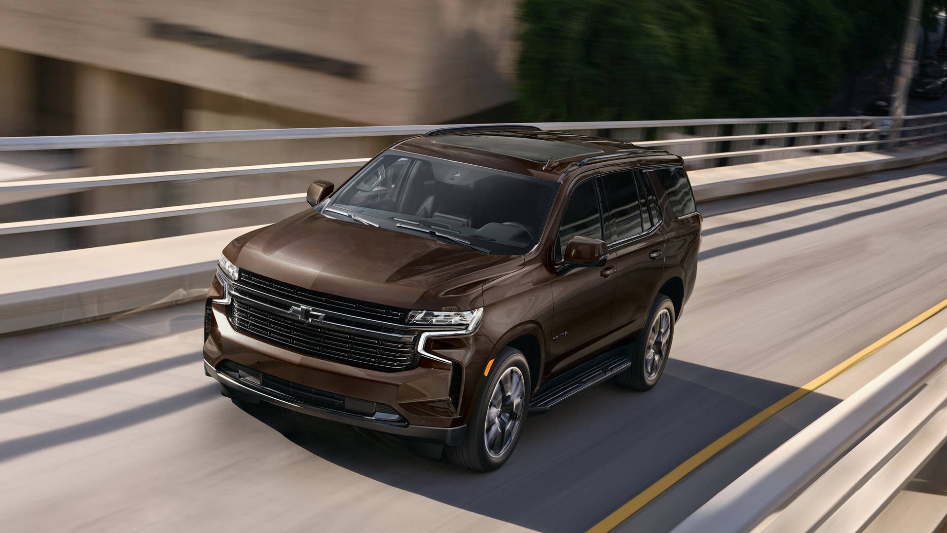 The 2023 Tahoe front three-quarter view driving.