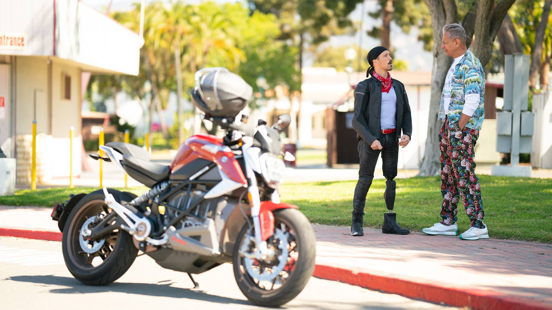 Santa Barbara, CA - Jeff Goldblum talks to Motorcycle enthusiast with motorcycle in the foreground. (Credit: National Geographic)