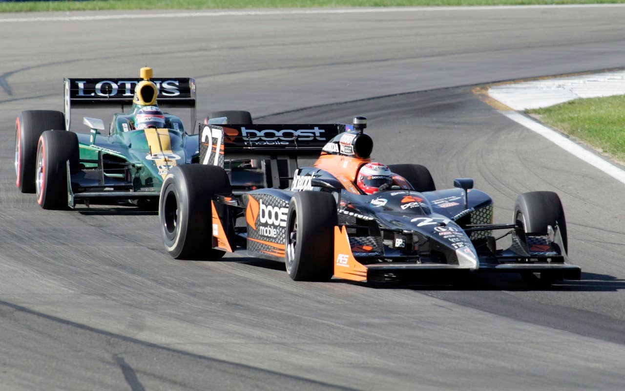 Adam Carroll, right, of Northern Ireland steers to control his race car as Takuma Sato of Japan follows through a turn Sunday, July 4, 2010, during the IndyCar Series'  Watkins Glen Camping World Grand Prix at The Glen in Watkins Glen, N.Y. (AP Photo/Michael Rogers)