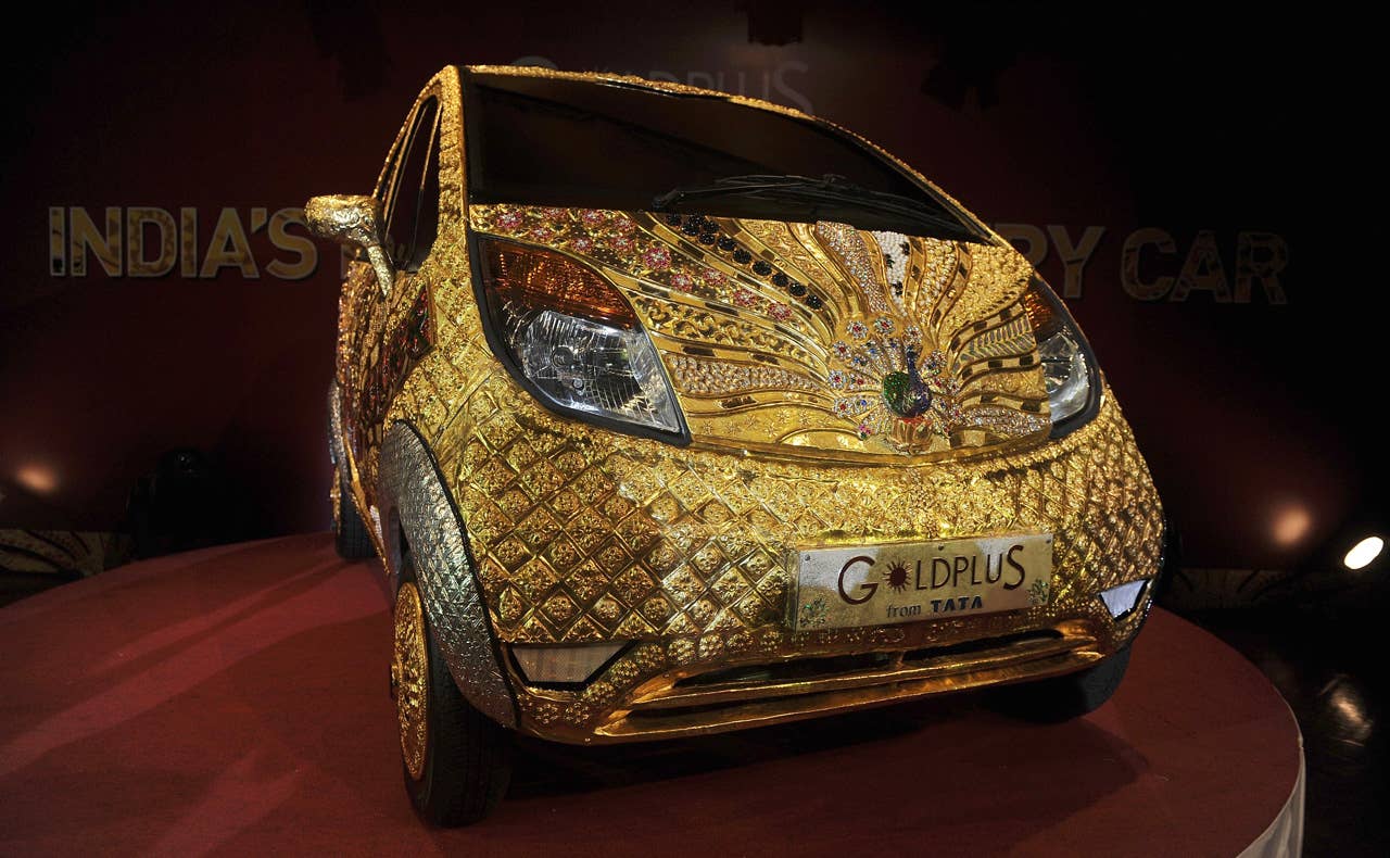A custom Tata Motors' 'Nano' car, is seen adorned in gold, silver and gemstone trimmings during its unveiling in Mumbai on September 19, 2011. The World's first Gold jewellery car, claimed by Tata, is made from 80 kilograms of 22 karat gold, 15 kilograms of silver, and numerous gemstones. AFP PHOTO/ Punit PARANJPE (Photo credit should read PUNIT PARANJPE/AFP/Getty Images)