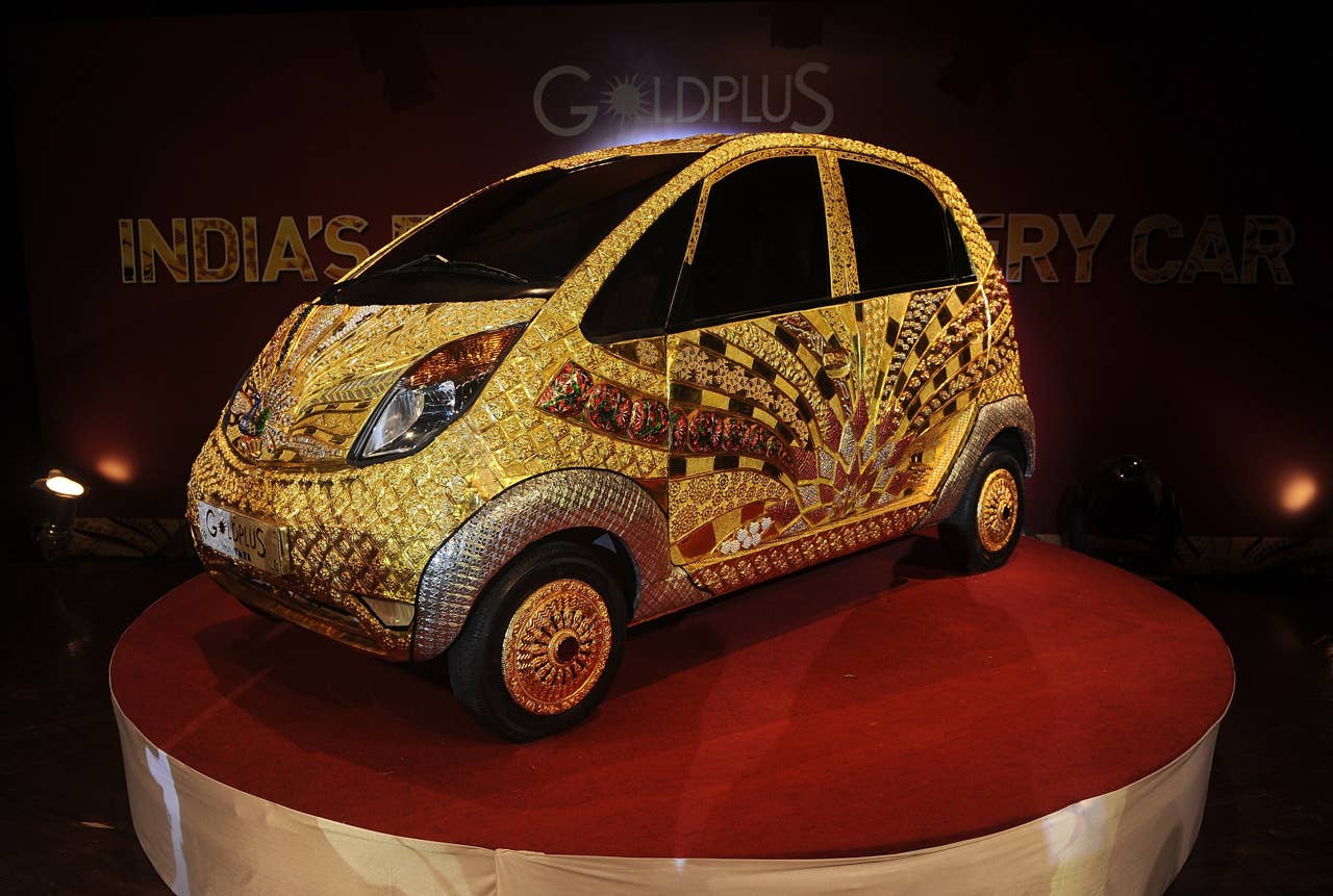 A custom Tata Motors' 'Nano' car, is seen adorned in gold, silver and gemstone trimmings during its unveiling in Mumbai on September 19, 2011. The World's first Gold jewellery car, claimed by Tata, is made from 80 kilograms of 22 karat gold, 15 kilograms of silver, and numerous gemstones. AFP PHOTO/ Punit PARANJPE (Photo credit should read PUNIT PARANJPE/AFP/Getty Images)