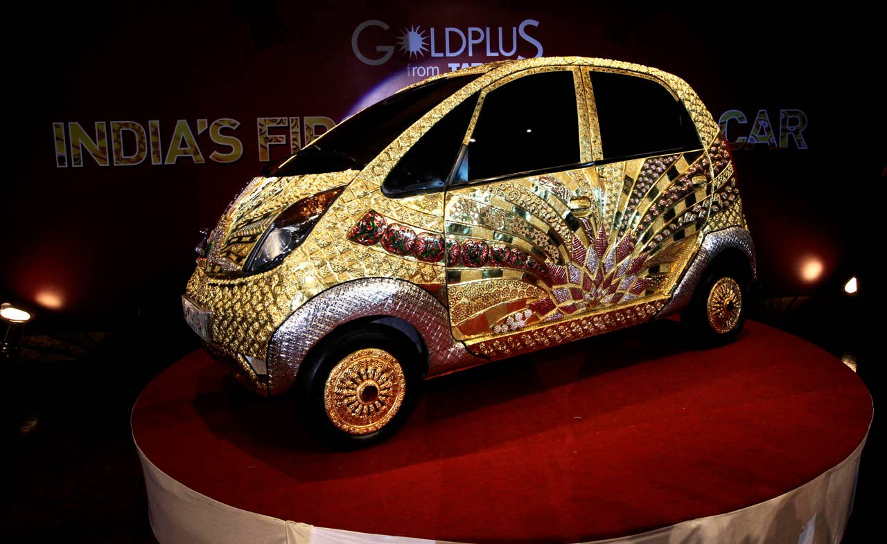 The Tata Motors 'Nano' car crafted in gold, silver and gem stones during its unveiling in Mumbai, India, Monday ,Sept. 19, 2011. This version of the compact car, which was launched two years ago as the world's cheapest car in its original form, is claimed to be first gold jewelry car and made from 80 kilograms of 22 karat gold, 15 kilograms of silver, and numerous gemstones. (AP Photo/Rajanish Kakade)