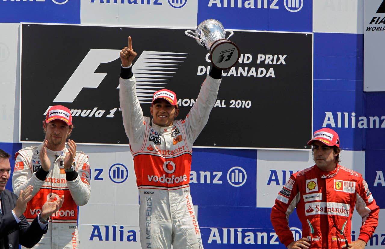 McLaren Mercedes driver Lewis Hamilton, middle, of Britain raises the trophy after winning the Canadian Grand Prix auto race in Montreal, Sunday, June 13, 2010. McLaren Mercedes driver Jenson Button, left, of Britain finished second while Ferrari driver Fernando Alonso of Spain finished third. (AP Photo/Darron Cummings)
