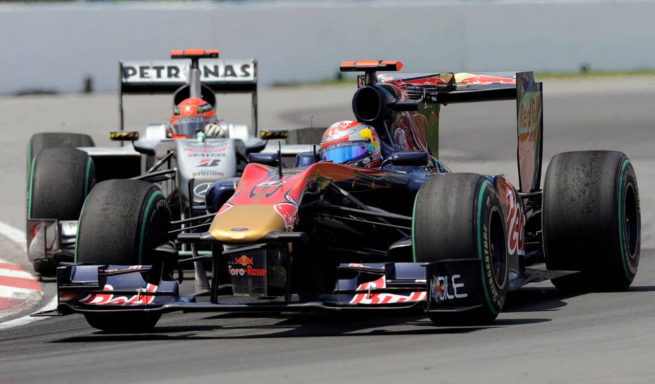 Toro Rosso driver Sebastien Buemi, of Switzerland, passes Mercedes driver Michael Schumacher, of Germany, during the Canadian Grand Prix auto race Sunday, June 13, 2010, in Montreal. (AP Photo/The Canadian Press, Graham Hughes)