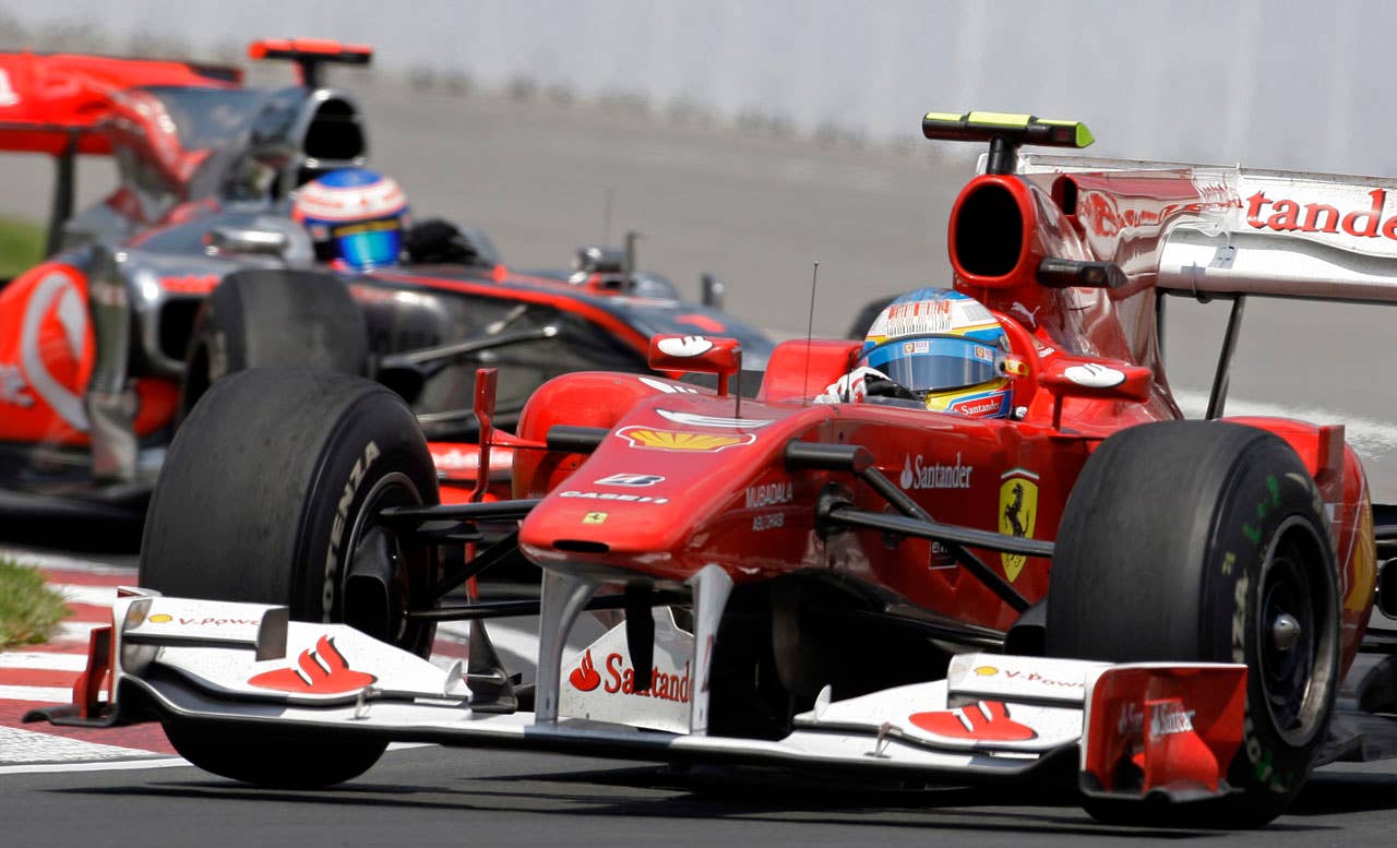 Ferrari driver Fernando Alonso, of Spain, rounds a corner during the Canadian Grand Prix auto race in Montreal, Sunday, June 13, 2010. Alonso finished in third place. At rear is McLaren's Jenson Button, of England, who finished in second. (AP Photo/Darron Cummings)