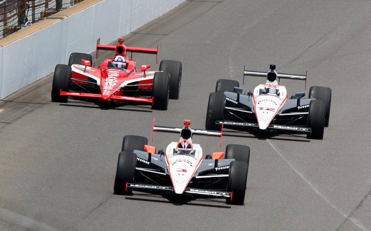 Helio Castroneves, of Brazil, leads Will Power, right, of Australia, and Dario Franchitti, left, of Scotland, into the first turn at the start of the Indianapolis 500 auto race at the Indianapolis Motor Speedway in Indianapolis, Sunday, May 30, 2010. (AP Photo/Mike Groll)