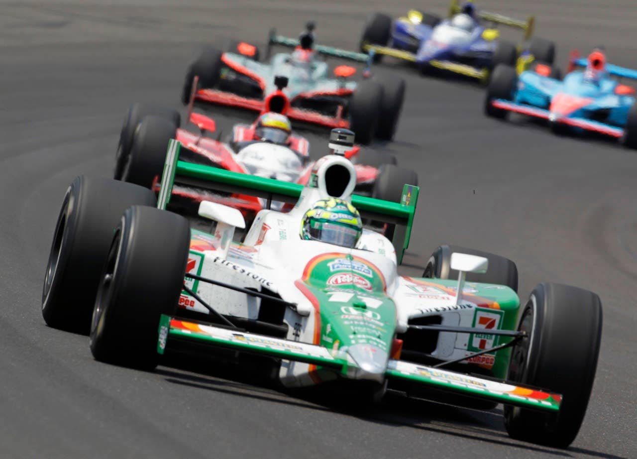 Tony Kanaan, of Brazil, leads a group of cars through the first turn during Indianapolis 500 auto race at the Indianapolis Motor Speedway in Indianapolis, Sunday, May 30, 2010. (AP Photo/Tom Strattman)
