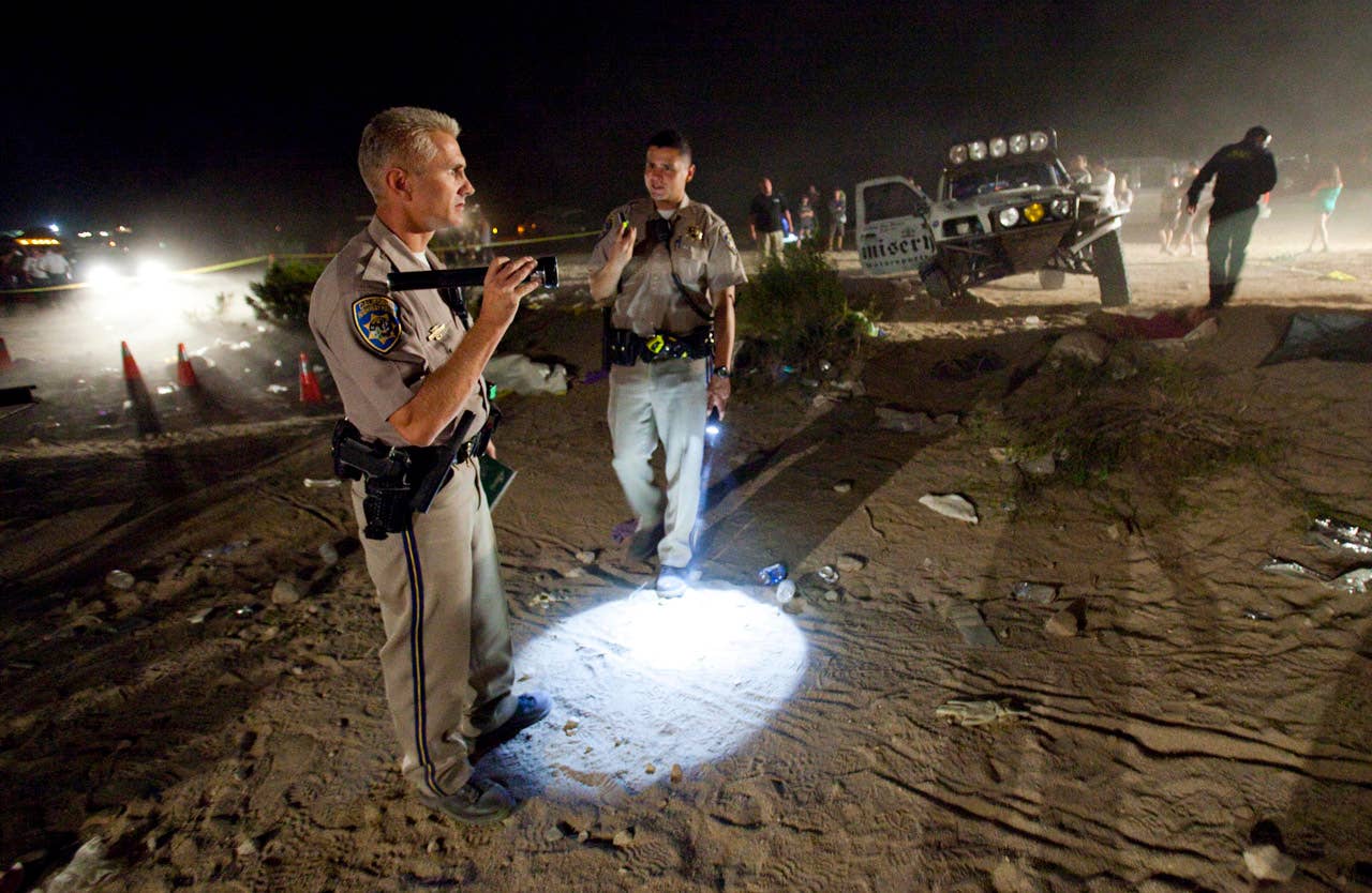 California Highway Patrol officers examine the accident scene Sunday where an off-road race truck went out of control and plowed into a crowd of spectators during a race in Lucerne Valley, Calif., Saturday Aug. 15, 2010. At least eight people were killed and 12 injured during the incident about 100 miles east of Los Angeles.(AP Photo/Francis Specker)