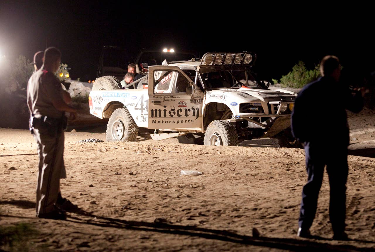 Law enforcement officers examine the accident scene Sunday where an off-road race truck, background, went out of control and plowed into a crowd of spectators during a race in Lucerne Valley, Calif., Saturday Aug. 14, 2010. At least eight people were killed and 12 injured during the incident about 100 miles east of Los Angeles.(AP Photo/Francis Specker)